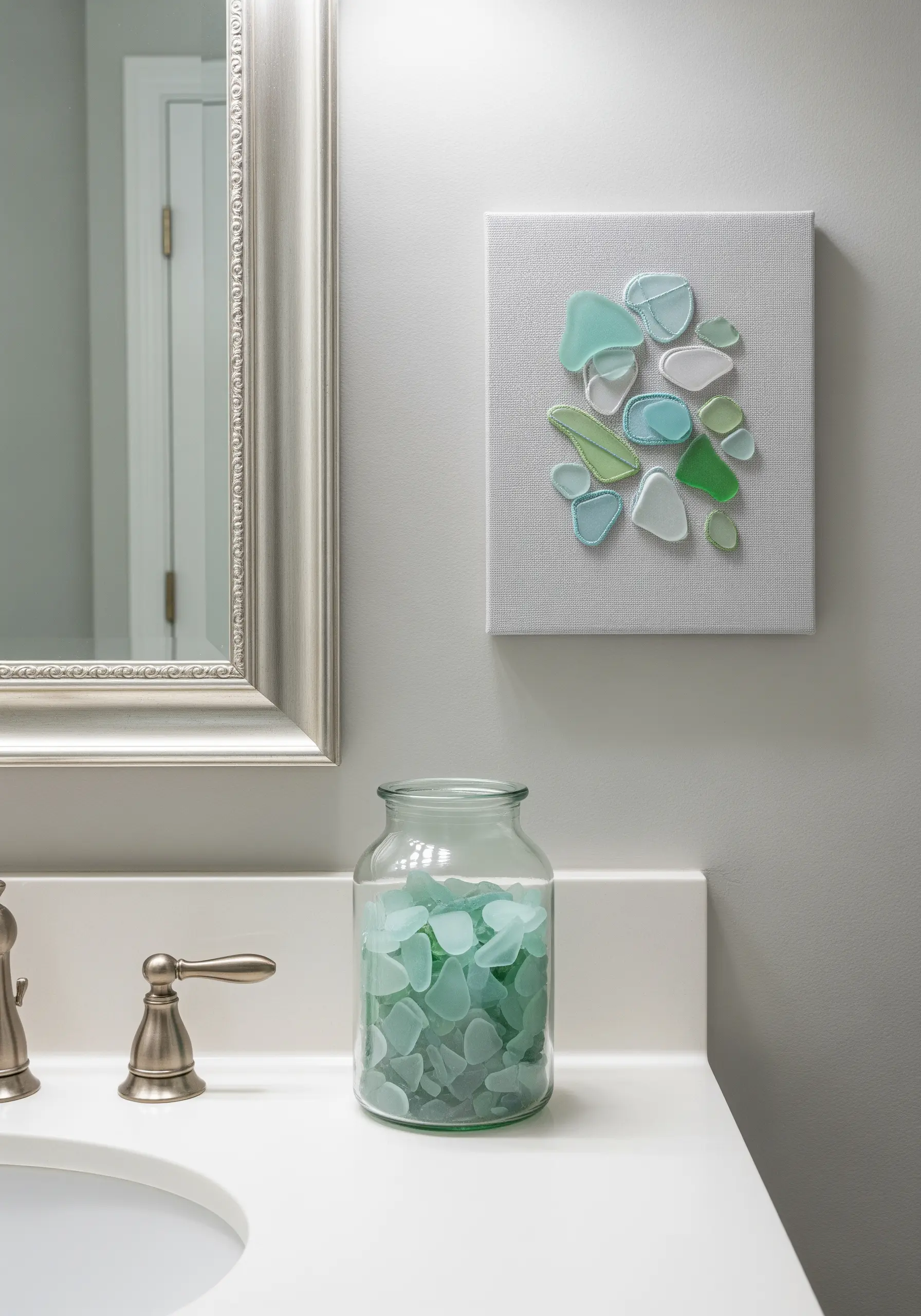 A mosaic of sea glass pieces outlined with white embroidery on canvas.