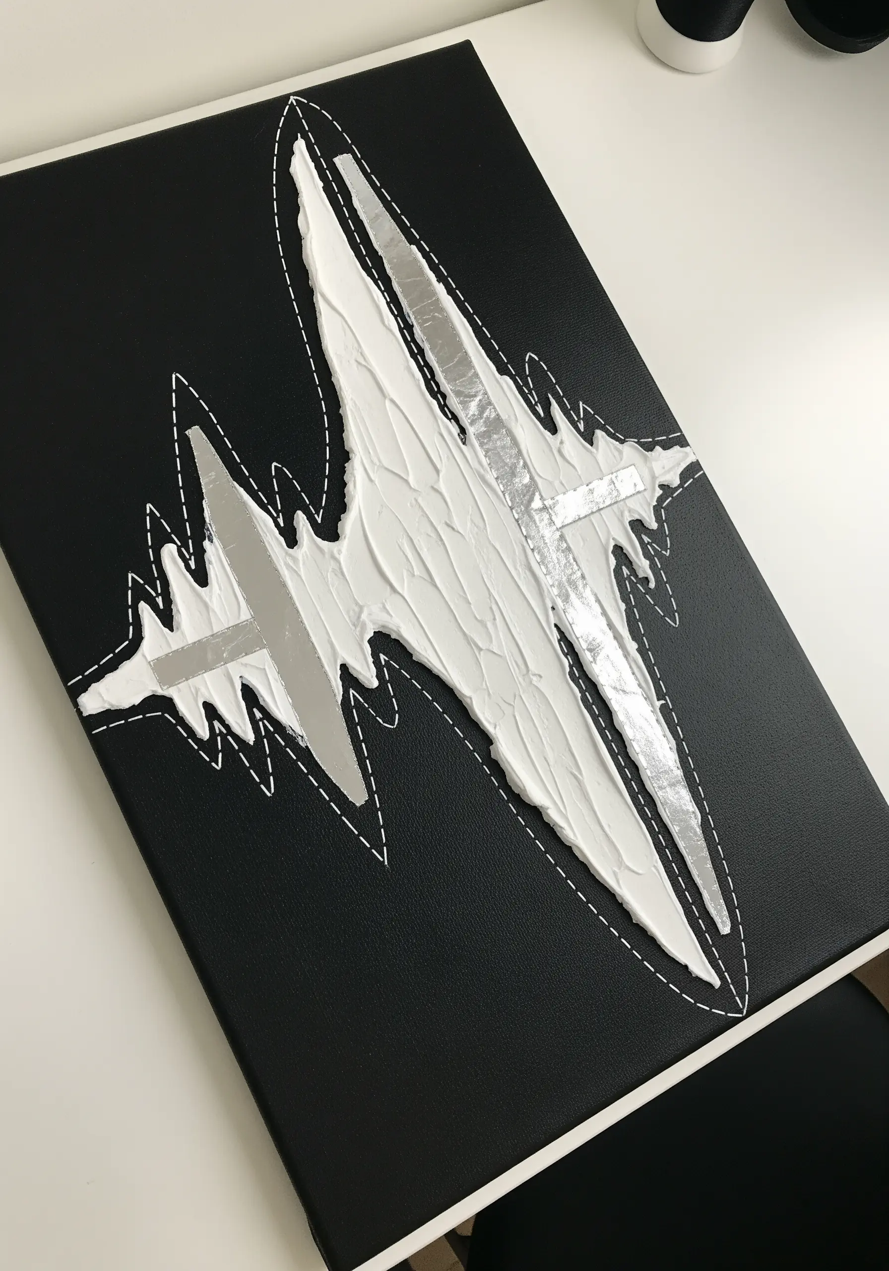 Abstract art on black canvas with white textural paste, silver foil, and a white running stitch outline.