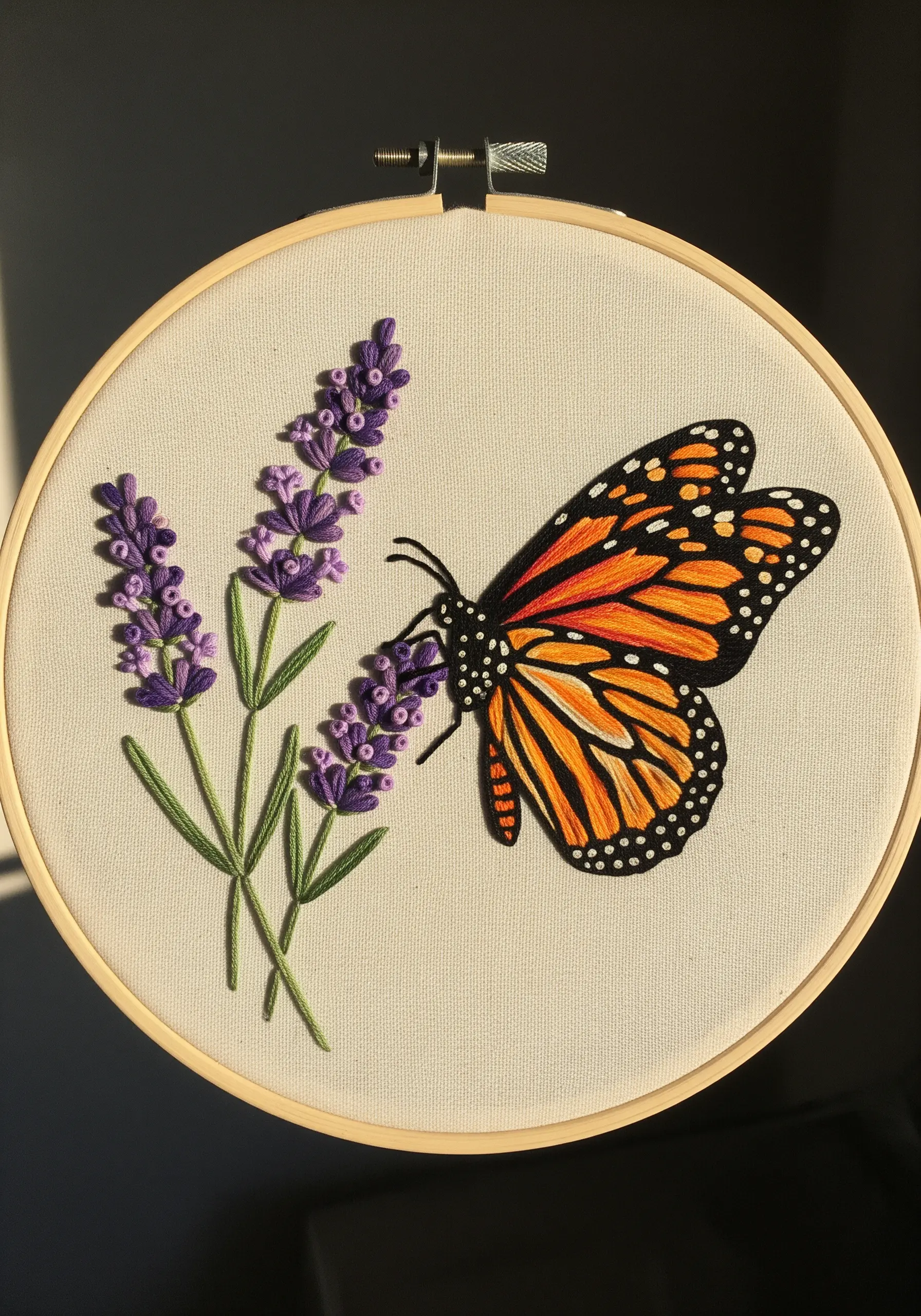 Thread-painted Monarch butterfly with orange gradients on dimensional purple lavender flowers.