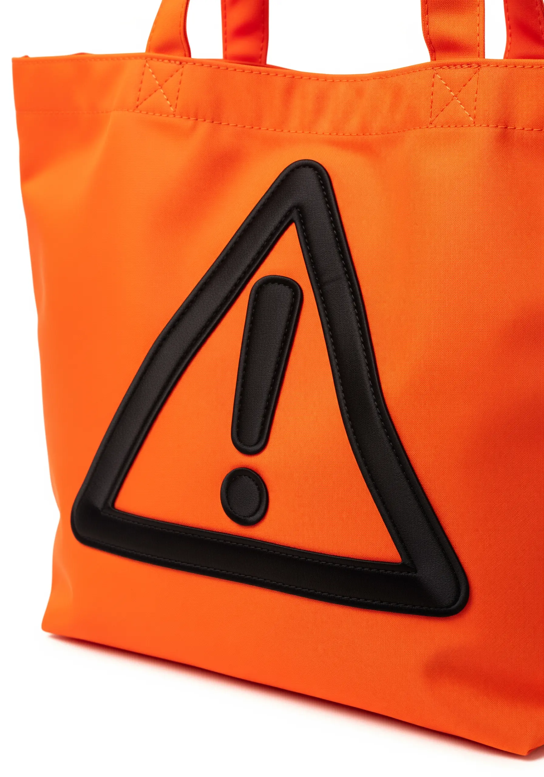 A black faux leather warning sign appliquéd onto a bright orange tote bag.