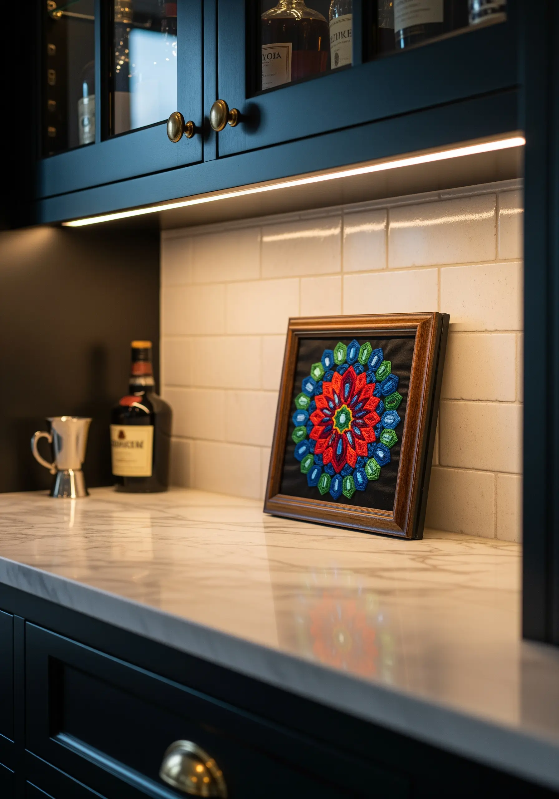 A brightly colored geometric mandala embroidery with bold black outlines in a dark frame.