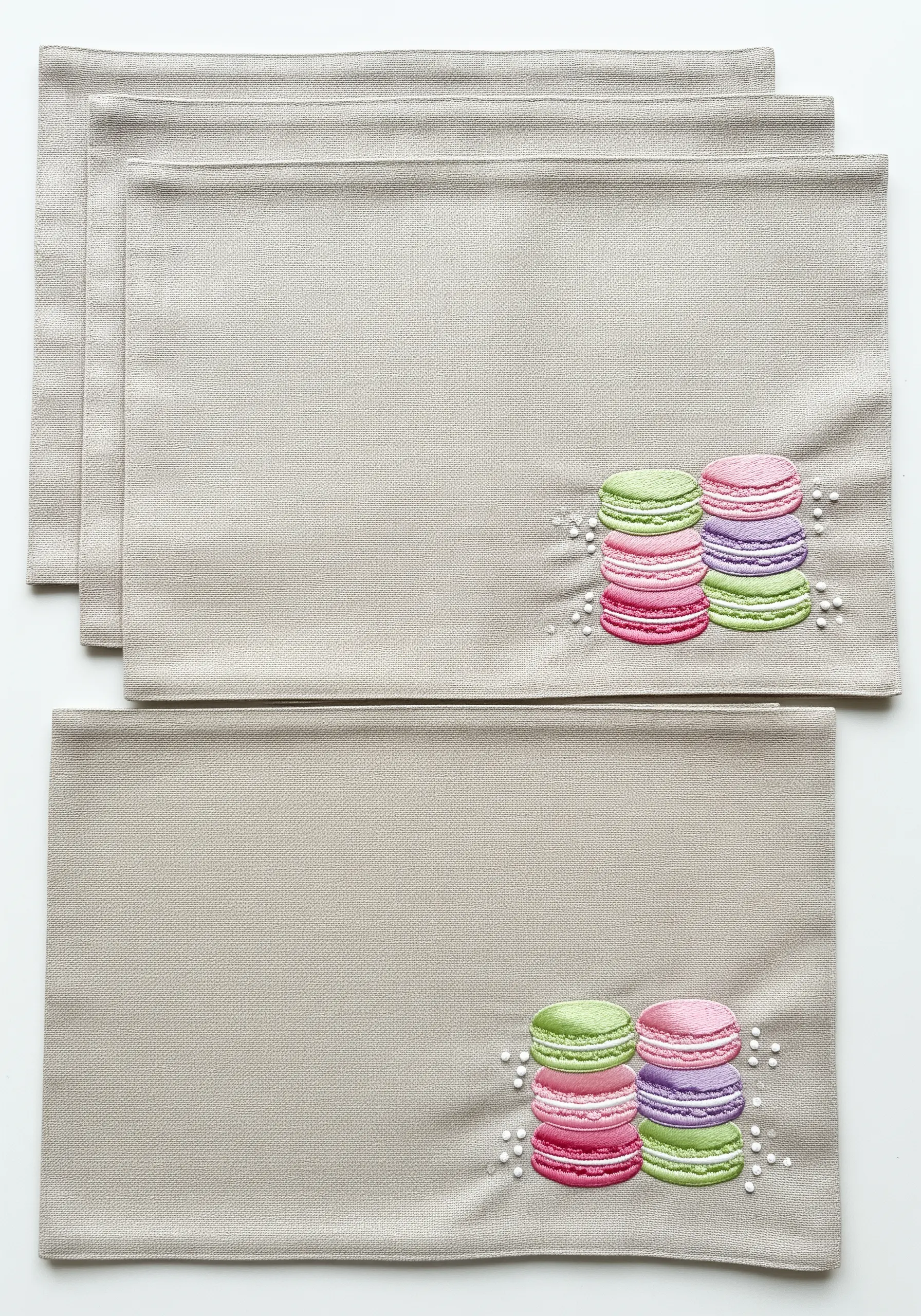 Colorful satin-stitched macarons with French knot details on a placemat.