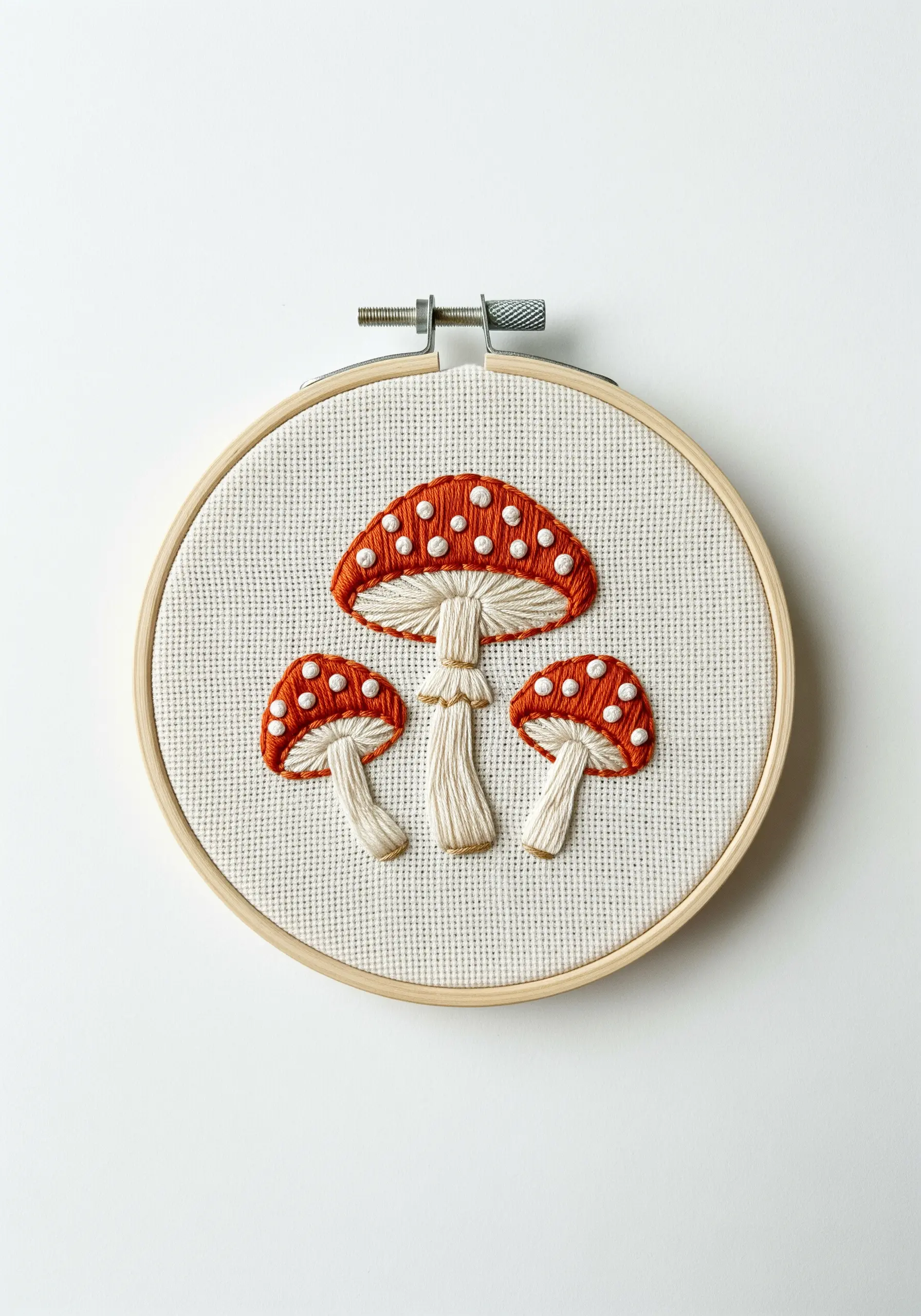 Three red-capped mushrooms with white French knot spots and shaded stems.