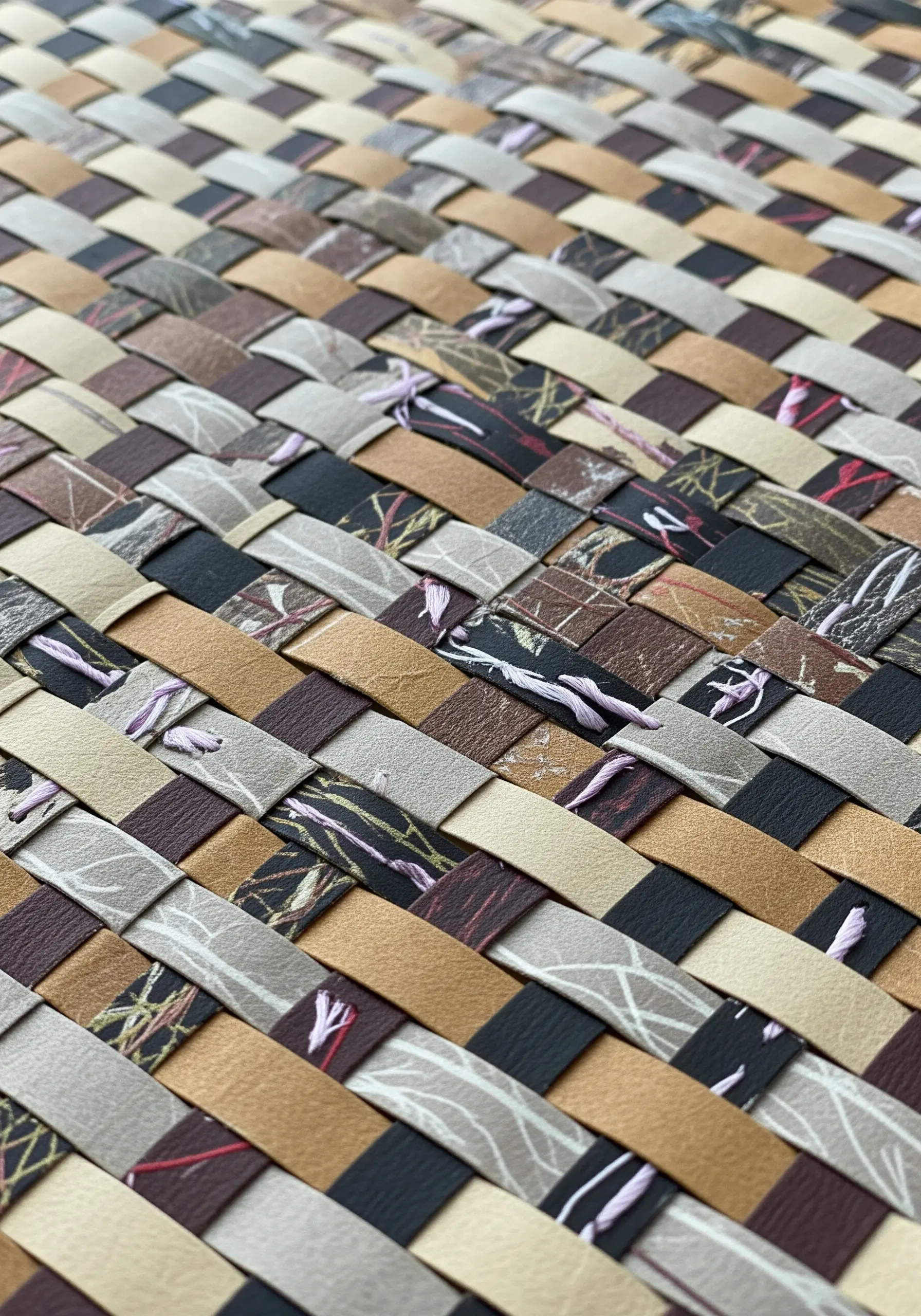 A close-up of a woven paper surface with small, subtle purple stitches at some intersections.