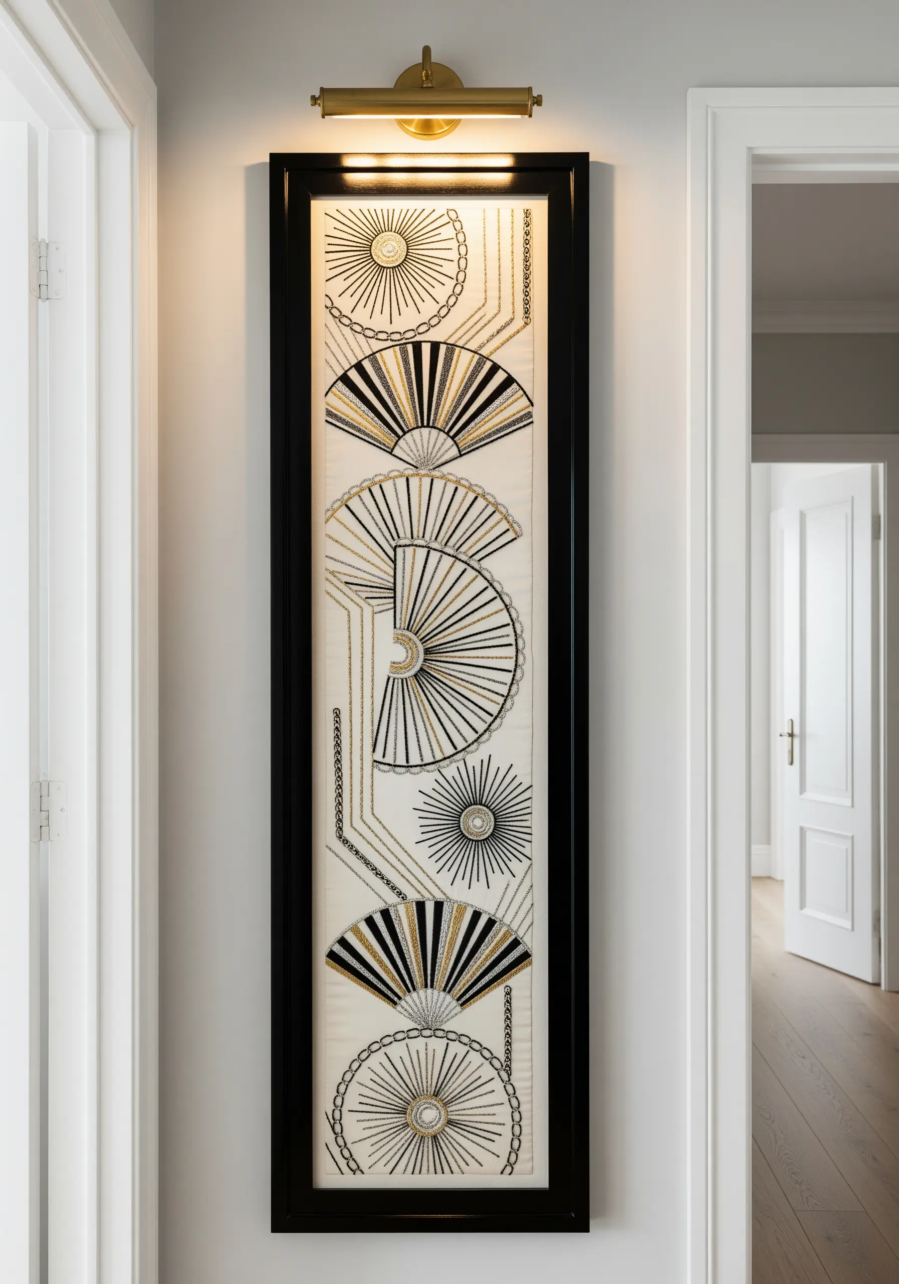 A narrow vertical embroidery with Art Deco-style fans in black, white, and gold thread.