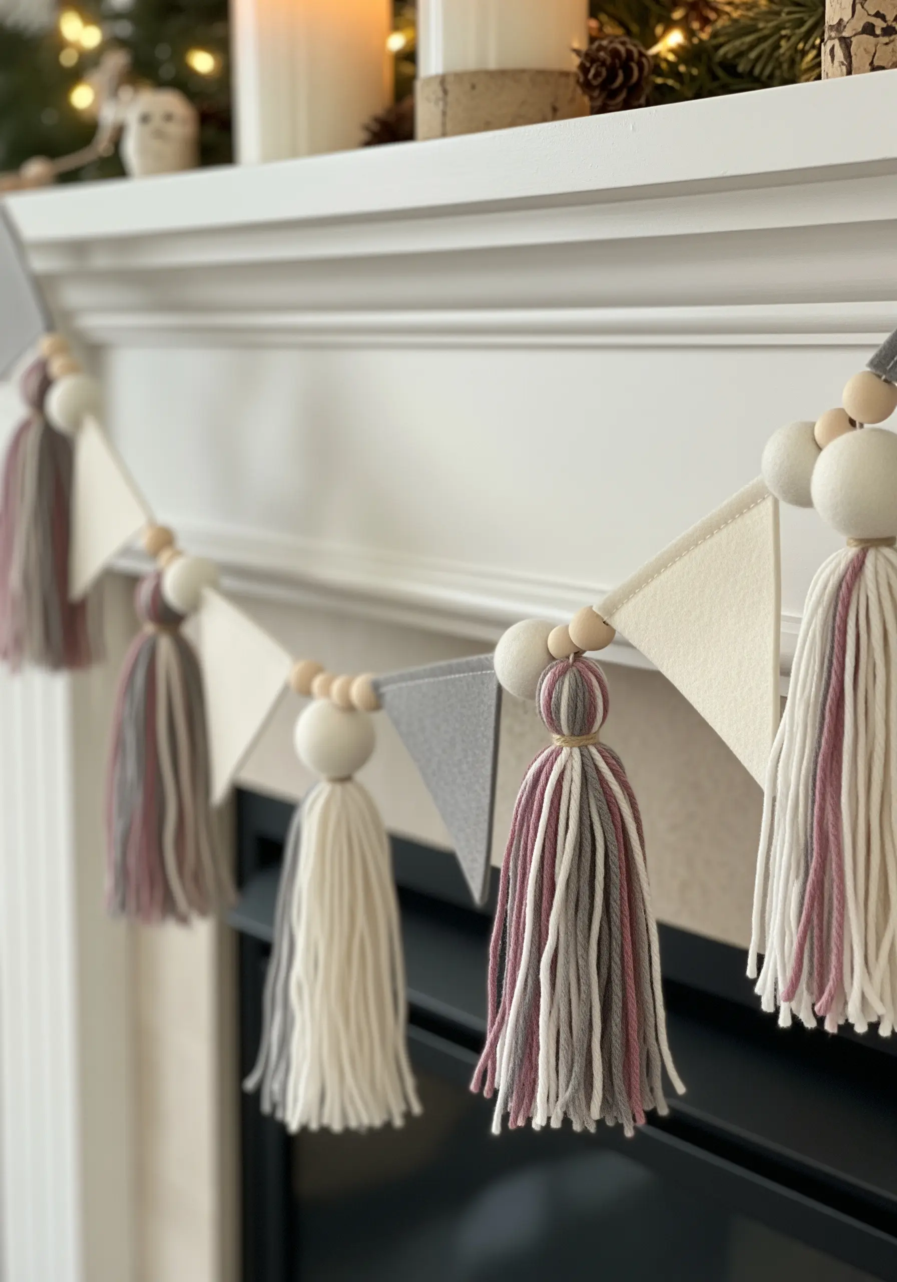 A mantelpiece garland made of felt triangles, wooden beads, and yarn tassels in muted tones.