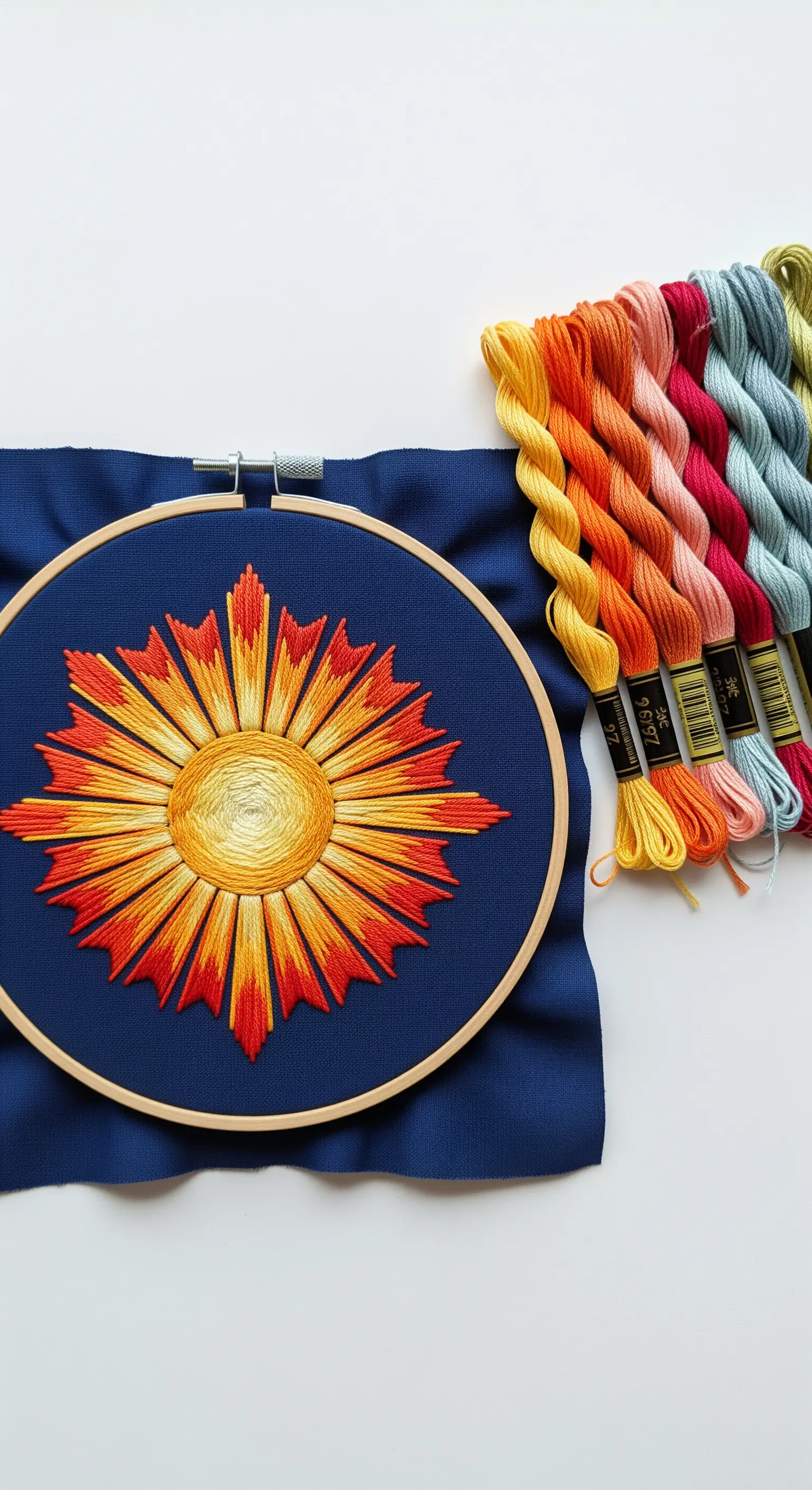 An embroidered sunburst with sharp rays in a red, orange, and yellow gradient.