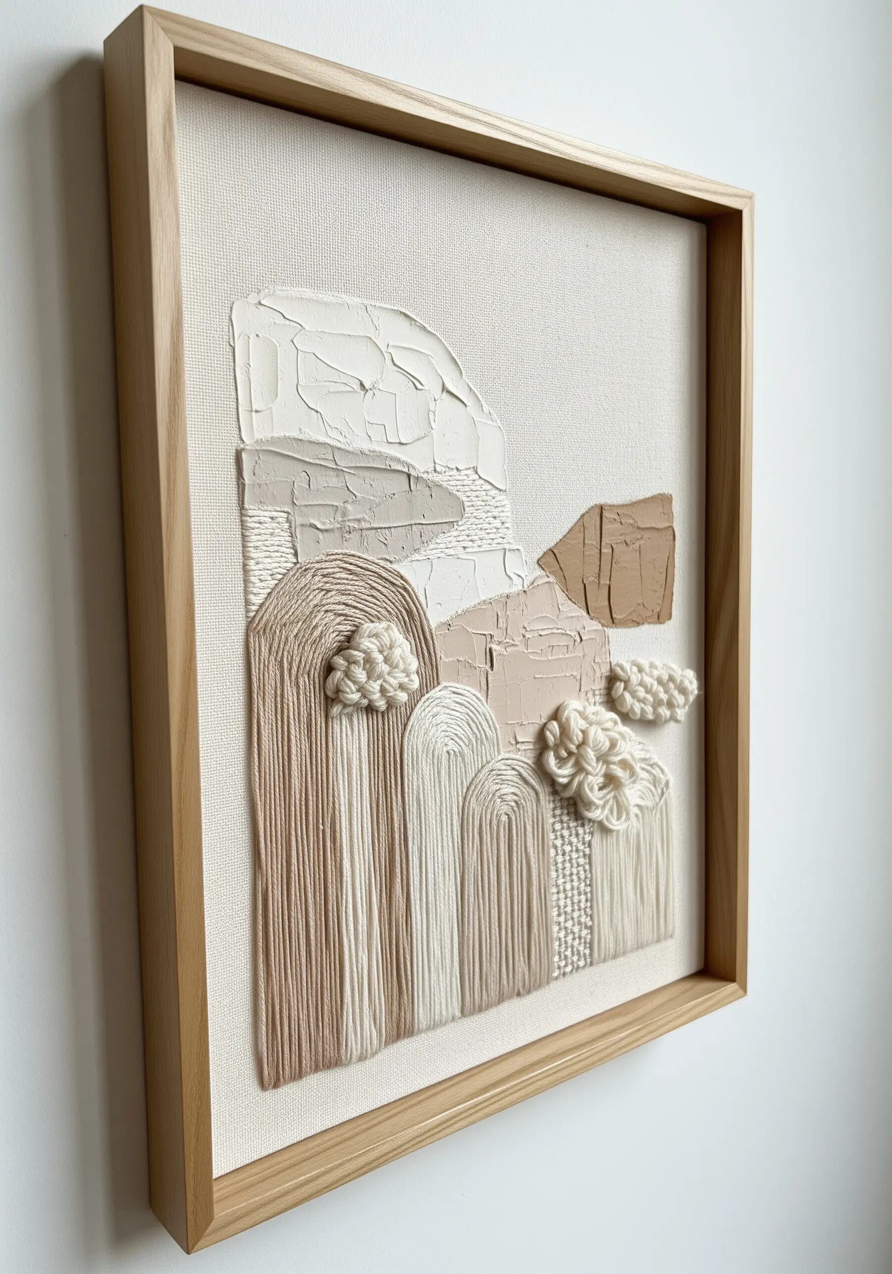Framed mixed-media art with thick white impasto, couched yarn arches, and woven knots.