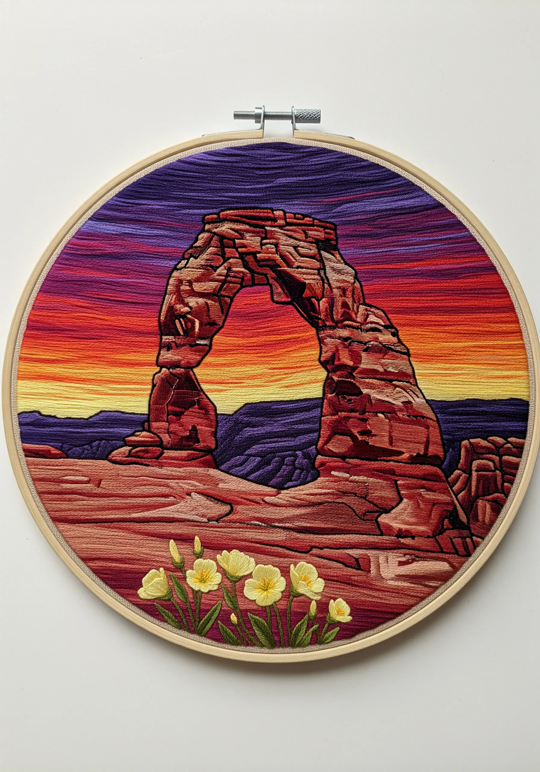 Embroidery of Delicate Arch against a vibrant, smoothly blended sunset sky.