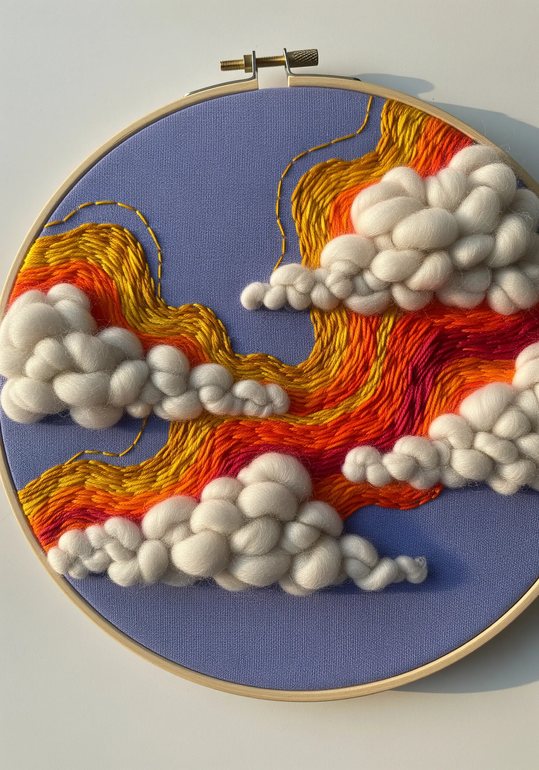 Hoop art combining sunset-colored thread painting and puffy wool roving clouds.