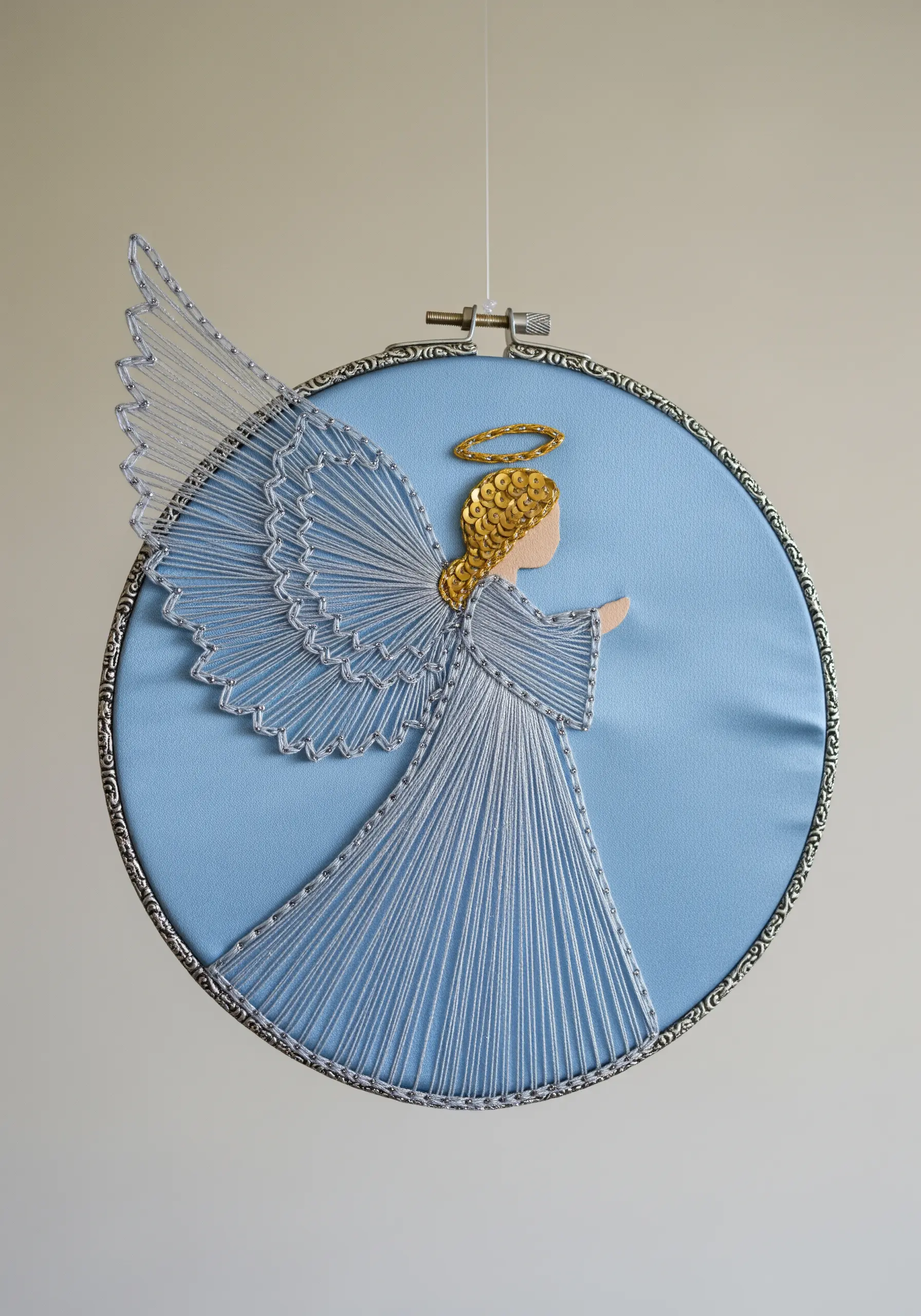String art angel with fine silver thread wings and a sparkling gold sequin halo.