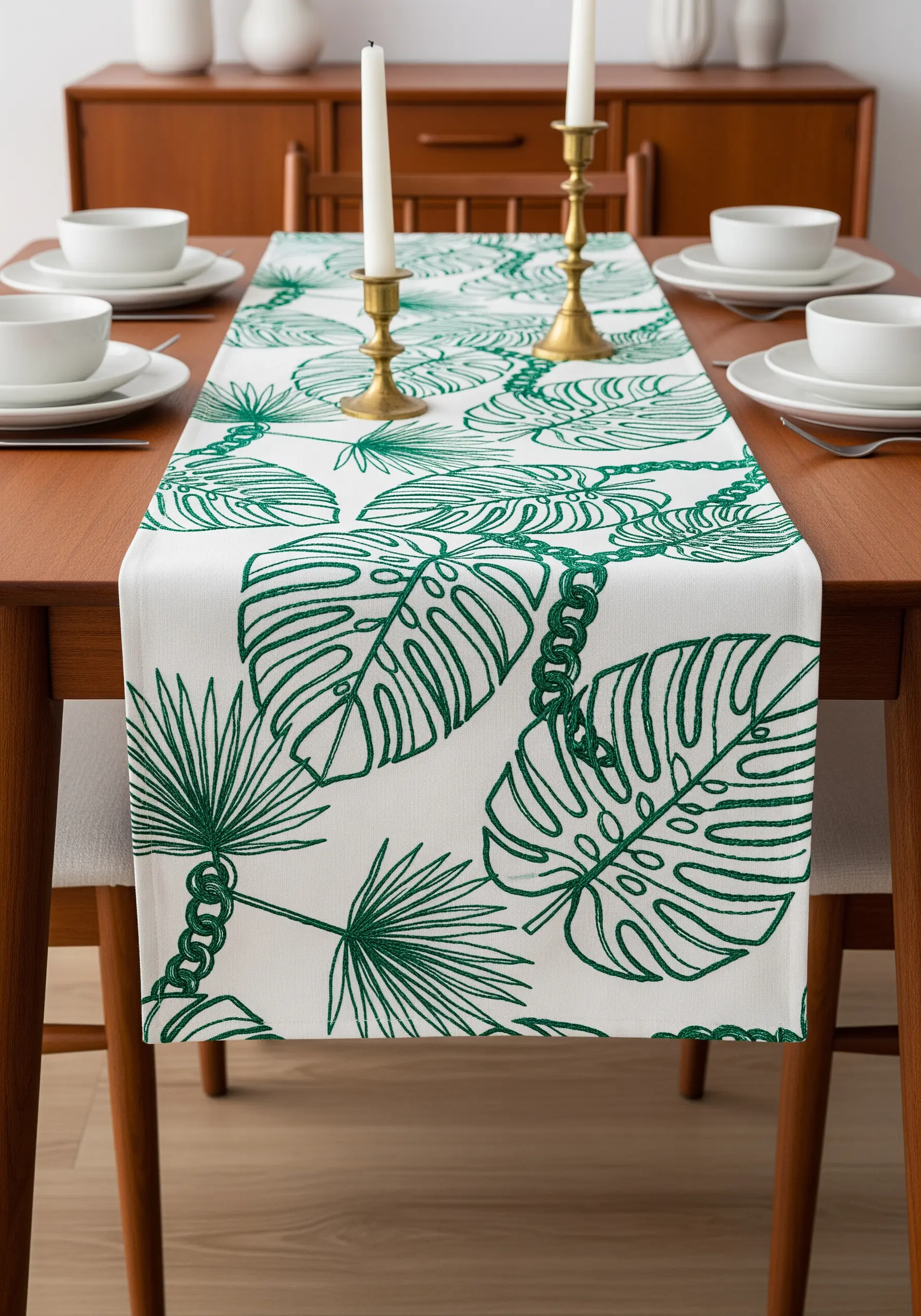 All-over pattern of tropical leaves embroidered in green chain stitch on a white runner.