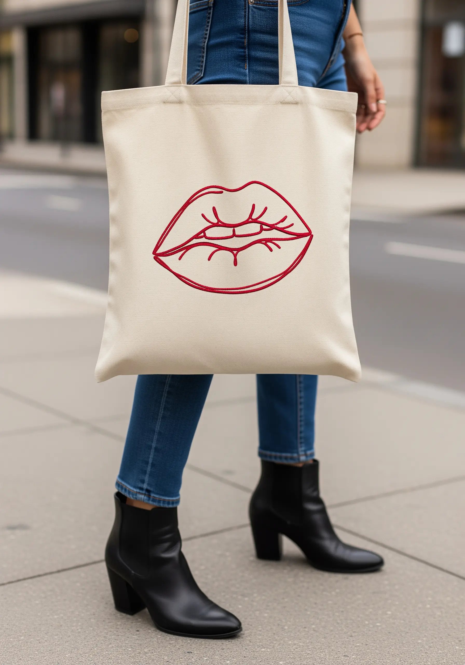 Bold red lips outlined with a raised satin stitch on a cream tote bag.