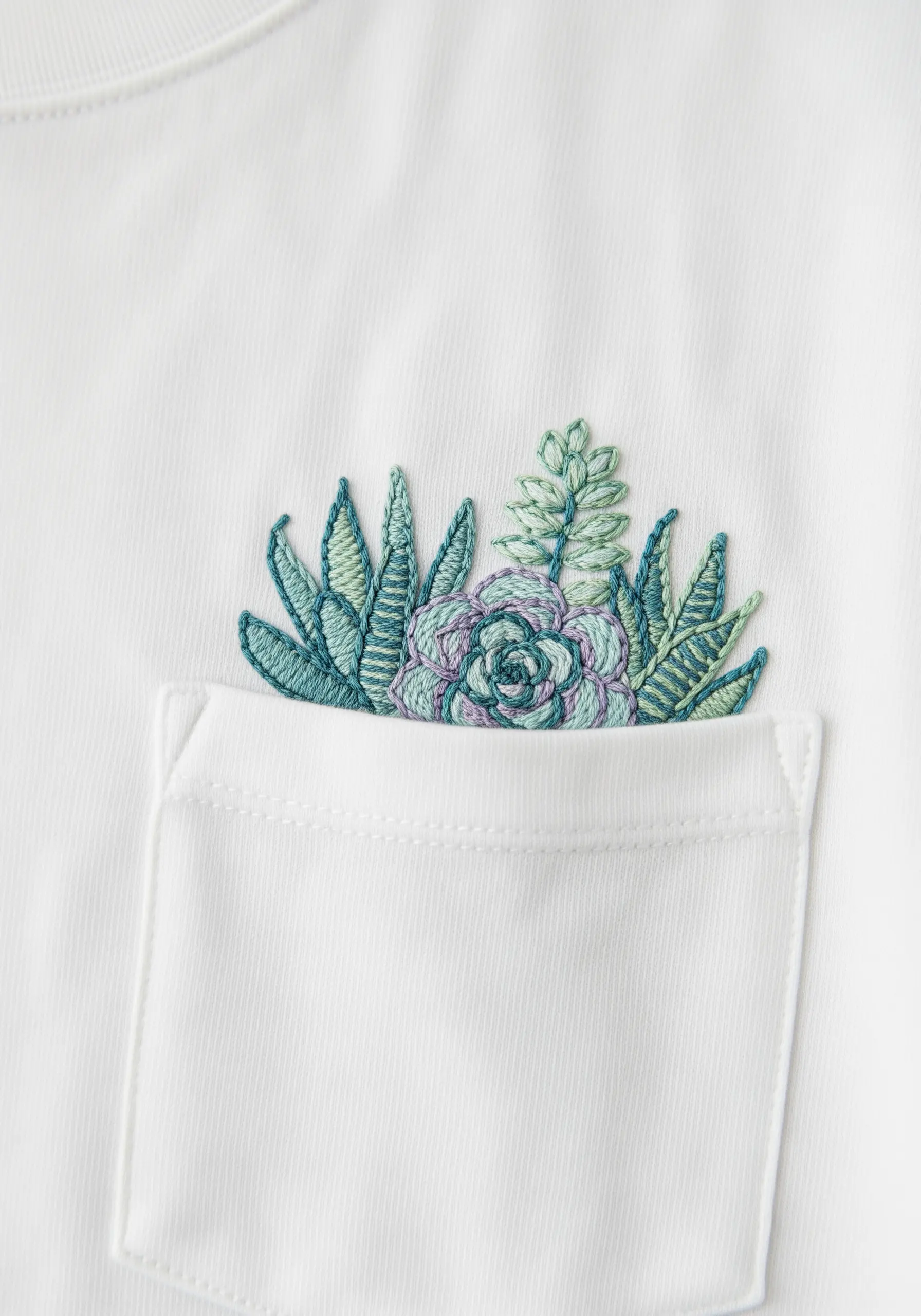 A cluster of embroidered succulents in blues and greens peeking from a pocket.