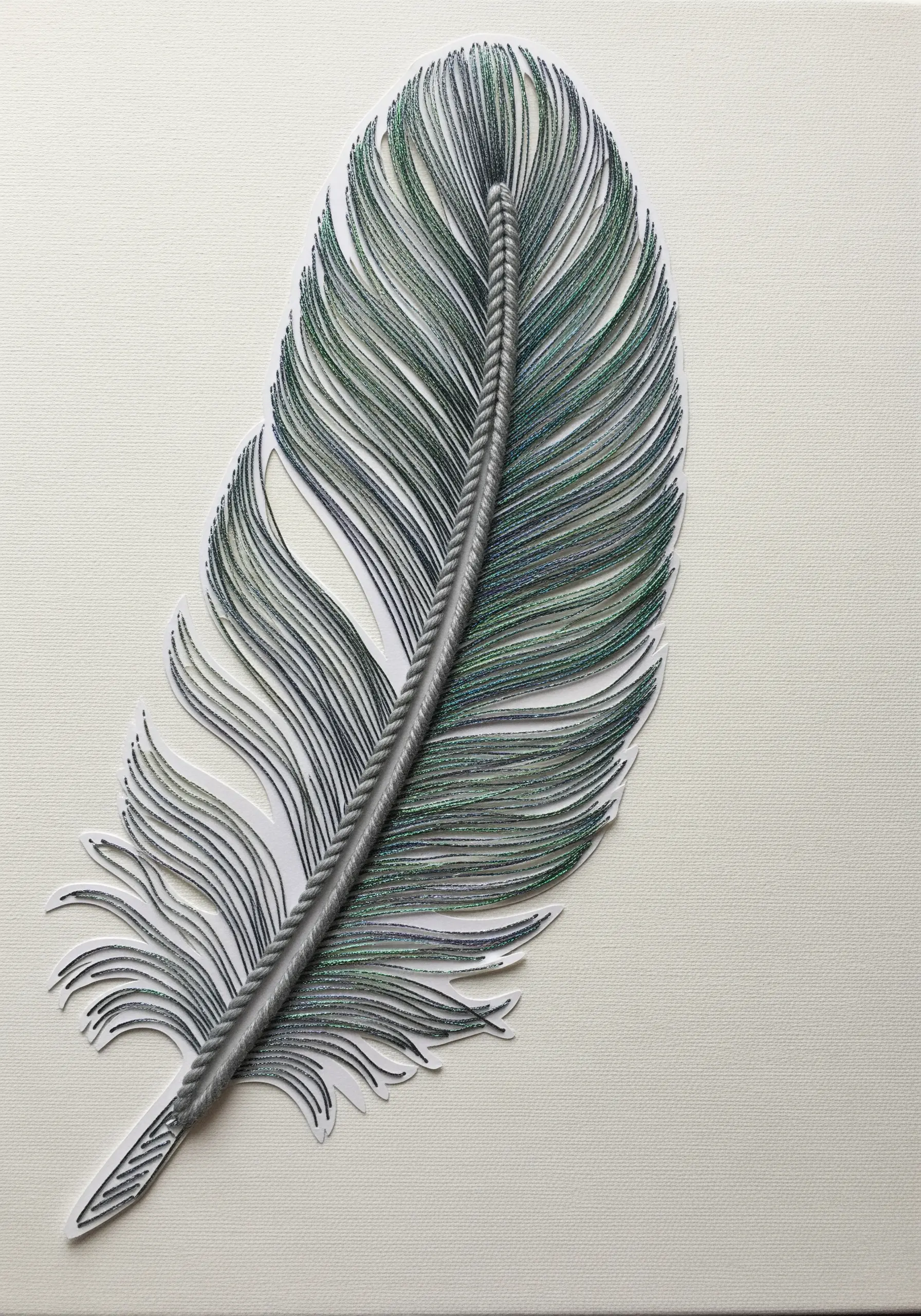 A highly realistic feather created by wrapping fine, variegated thread around a paper cutout.