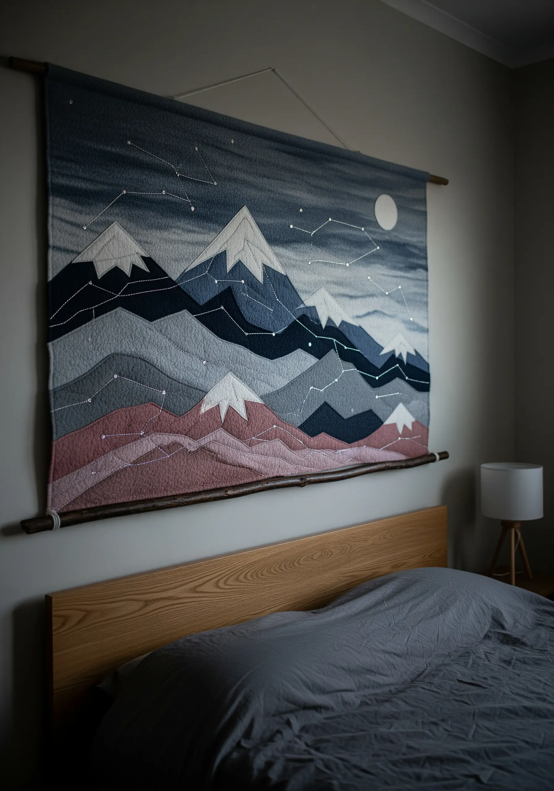 Large fabric wall hanging of a mountain range with embroidered constellation lines.