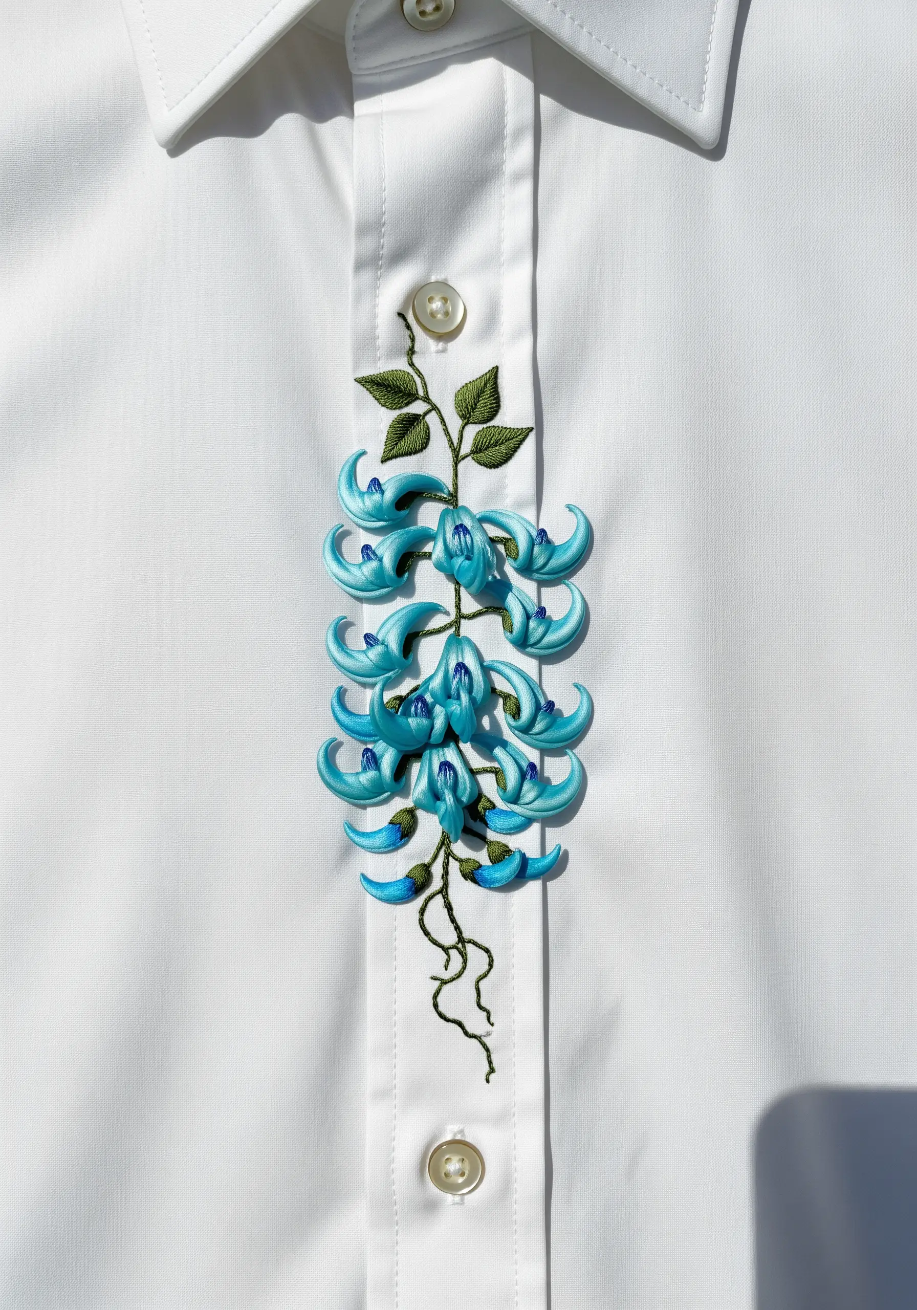 A cascading blue-green Jade Vine embroidered down the placket of a white shirt.