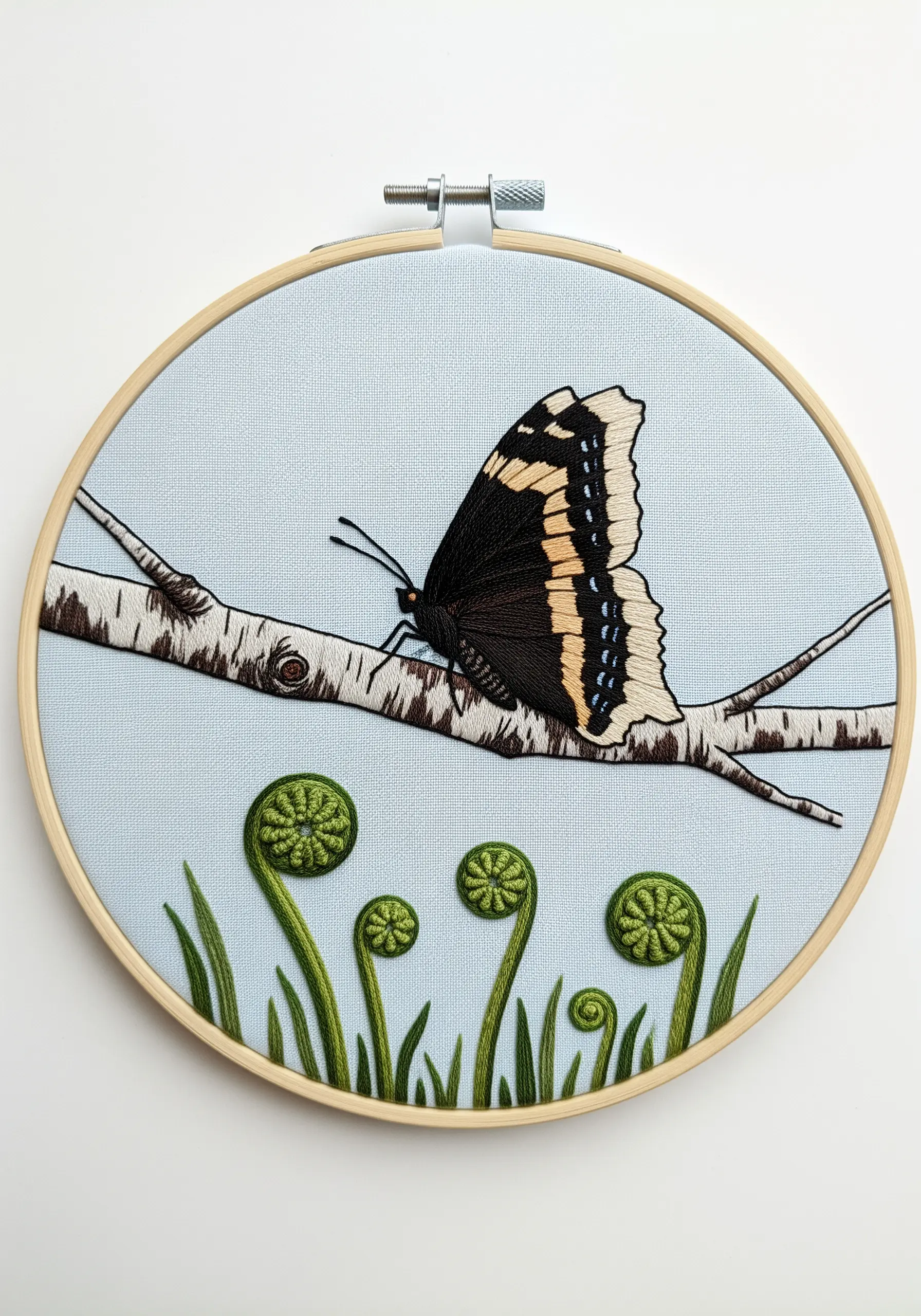 Butterfly on a birch branch with coiled fern fiddleheads embroidered in dimensional stitches.