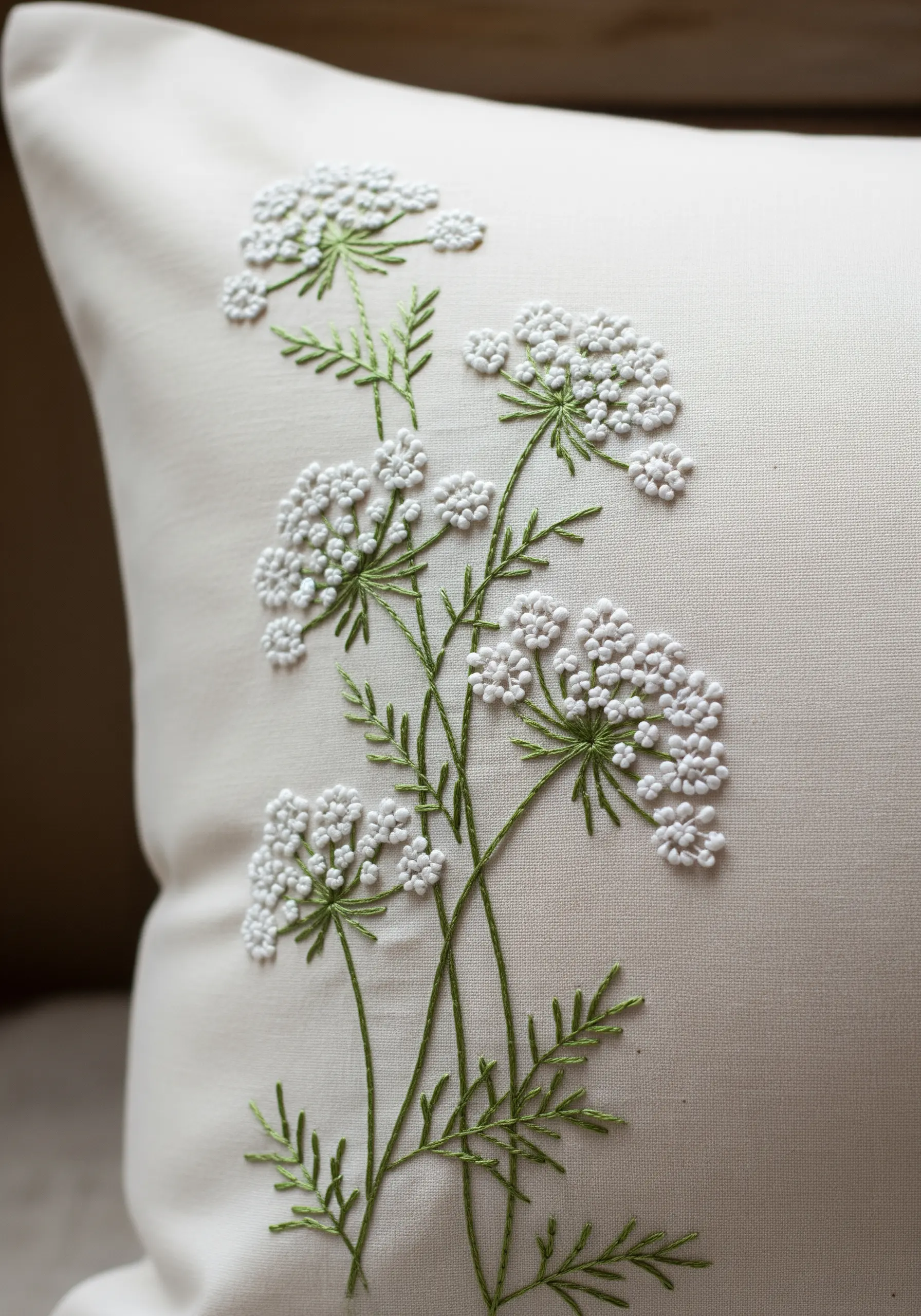 Delicate Queen Anne's Lace embroidered with white French knots and fine green stems.