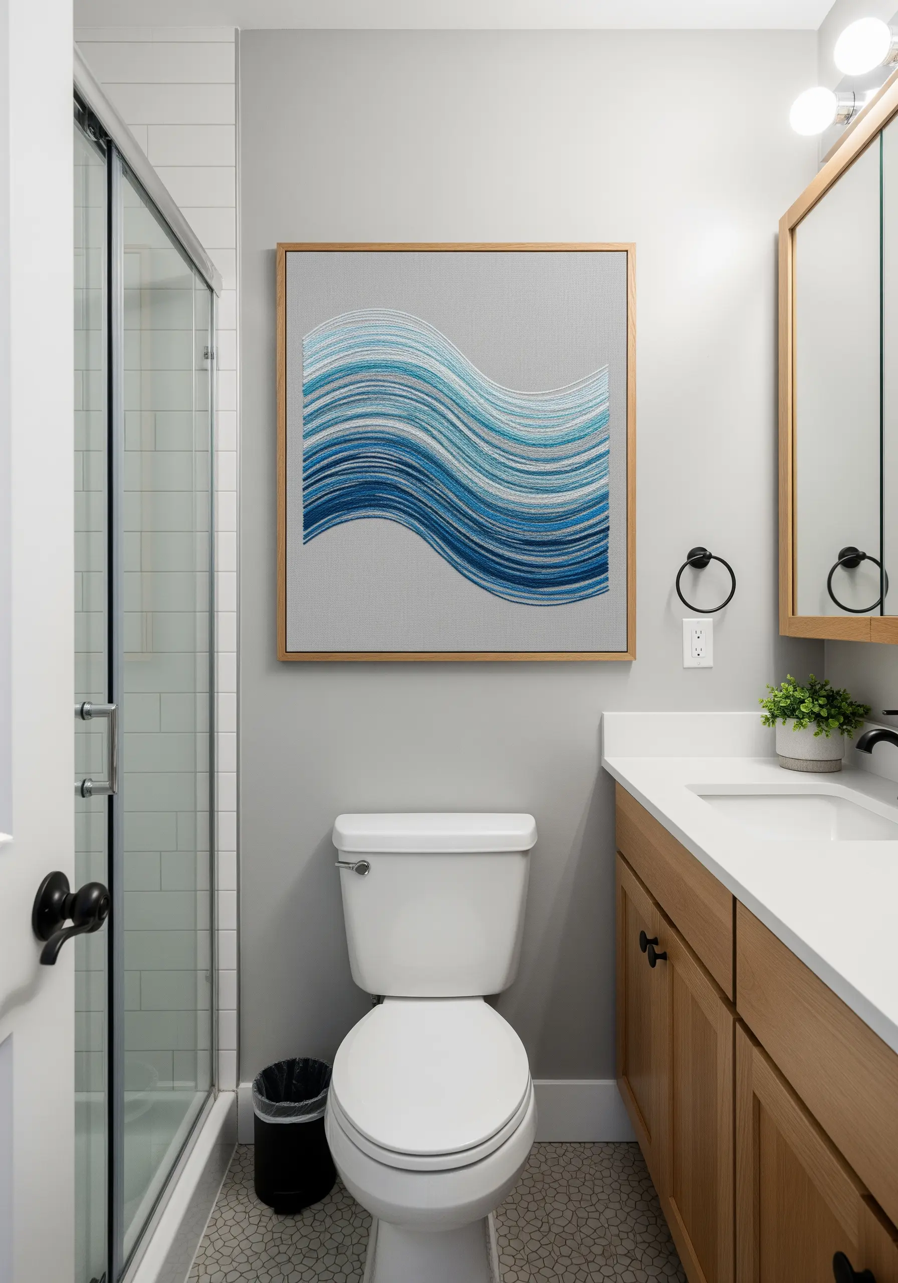 Framed embroidery of an abstract wave made of graduating shades of blue horizontal stitches.