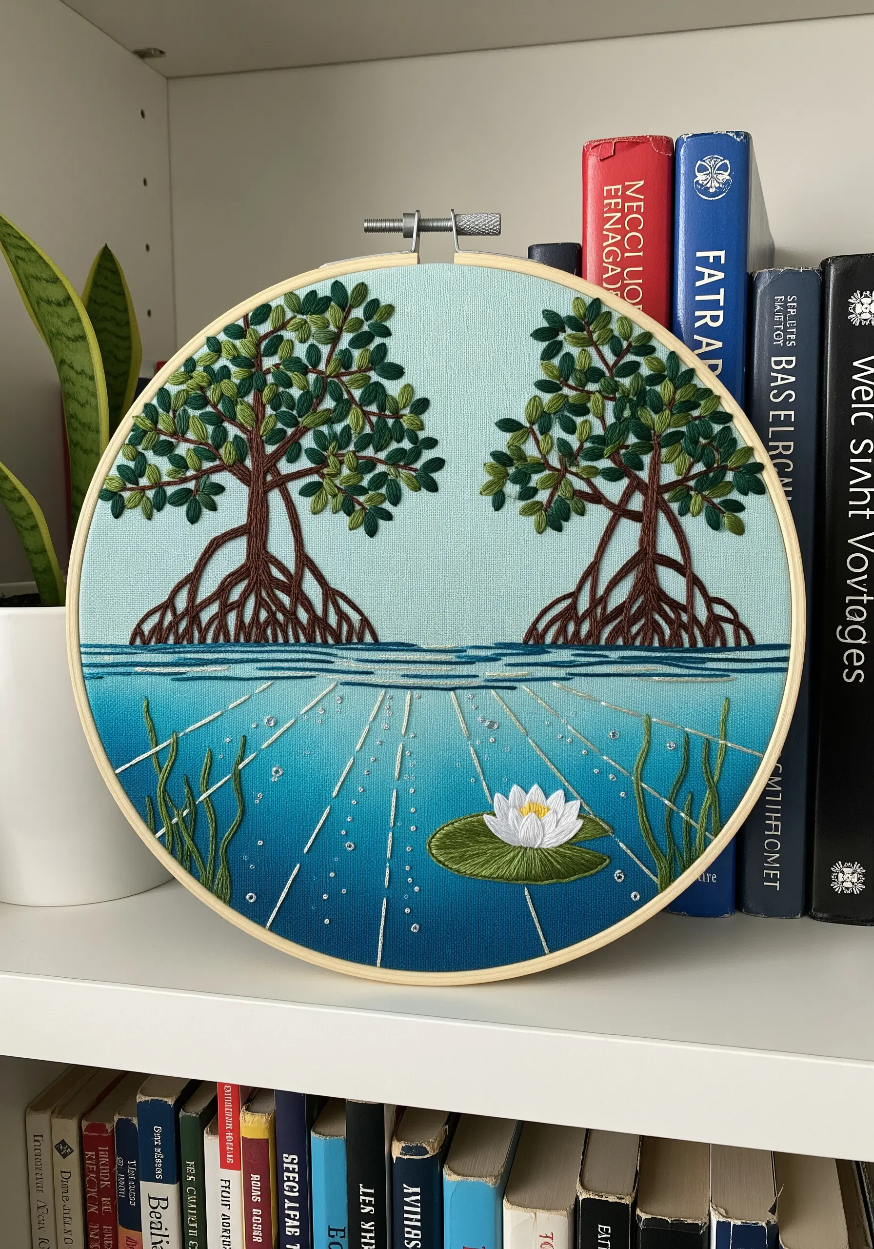 Embroidery of mangrove trees with visible roots and an underwater scene with light rays.