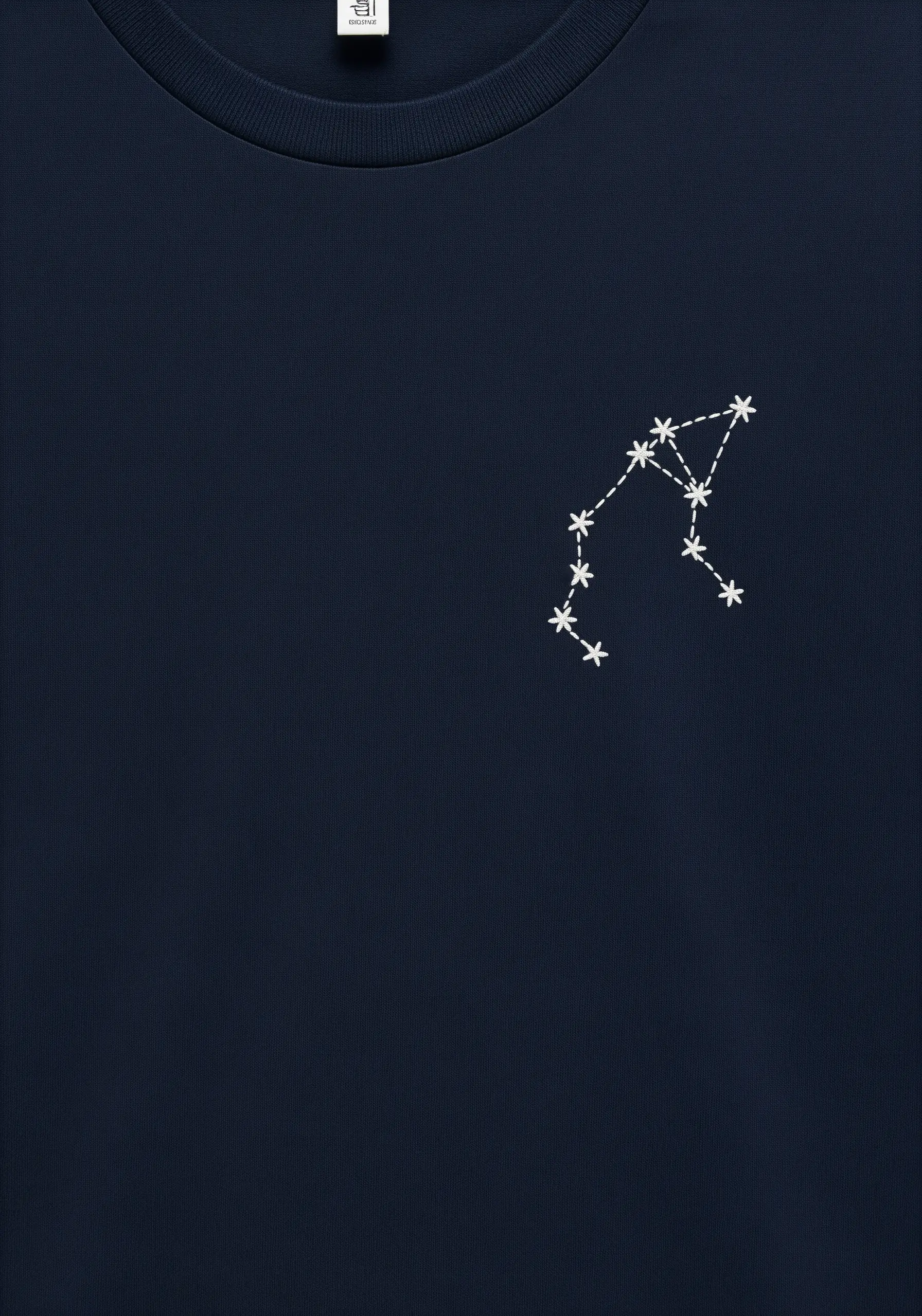 A delicate white embroidered constellation on the chest of a dark navy sweatshirt.