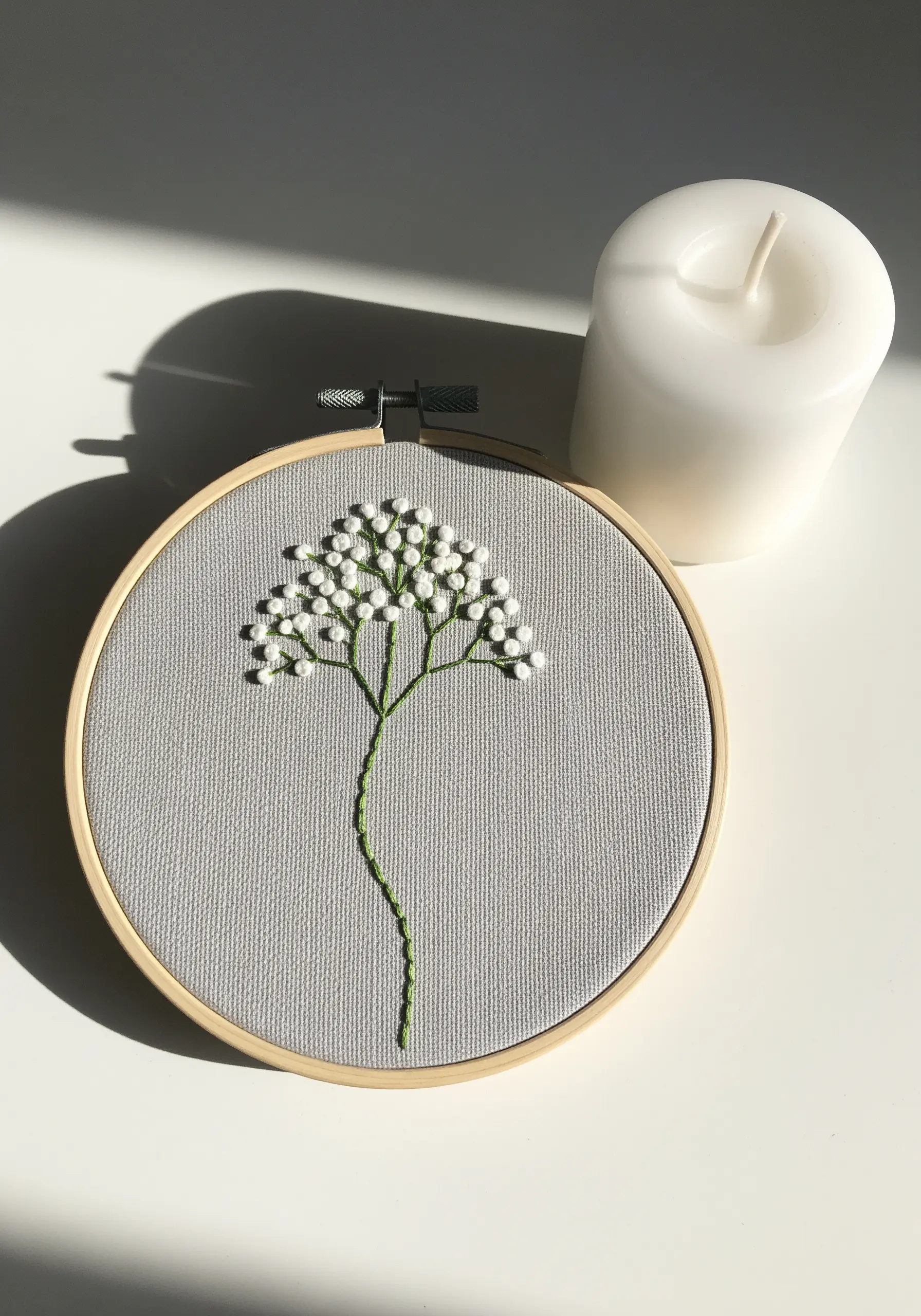 A branch of baby's breath embroidered with green stems and clusters of white French knots.