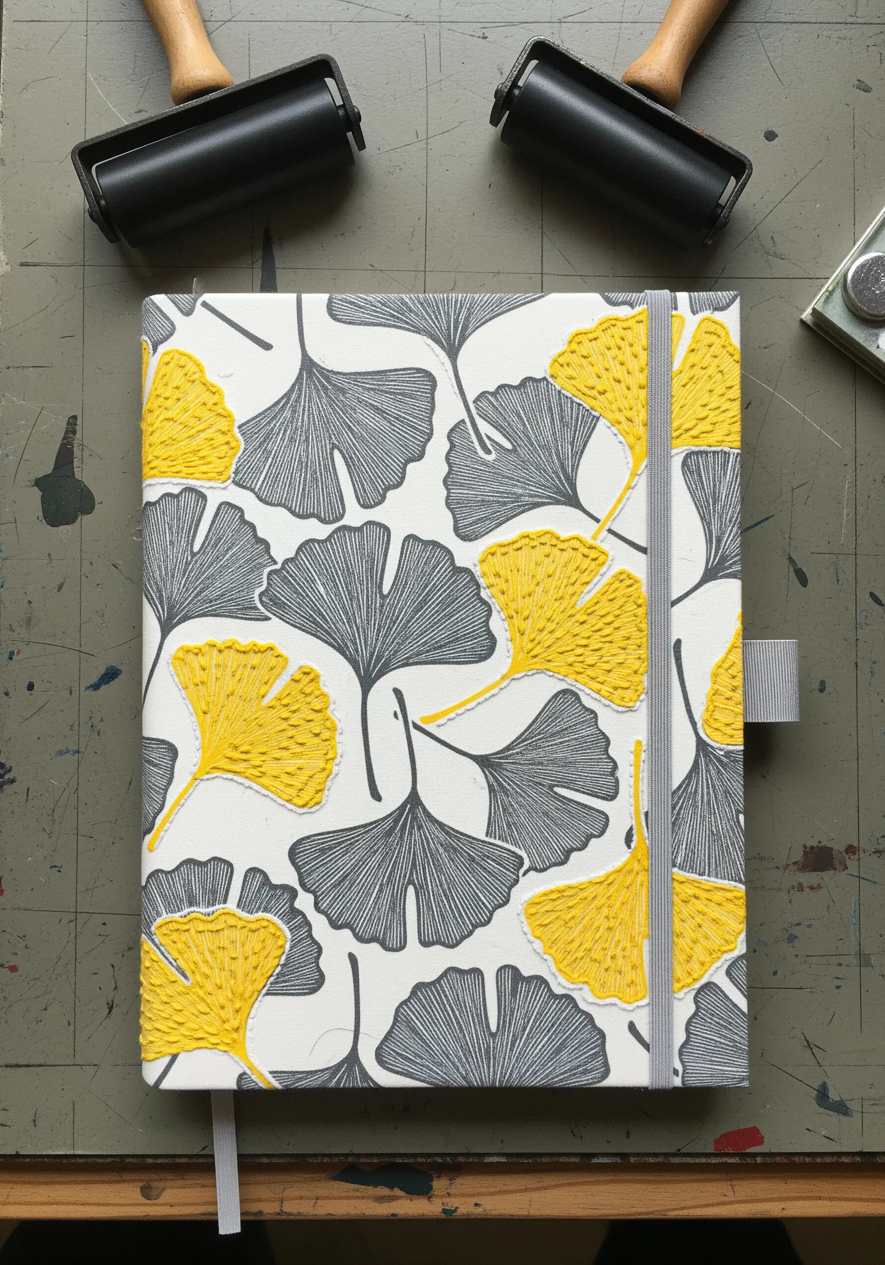 A pattern of grey and yellow ginkgo leaves, where the yellow leaves are filled with embroidery.