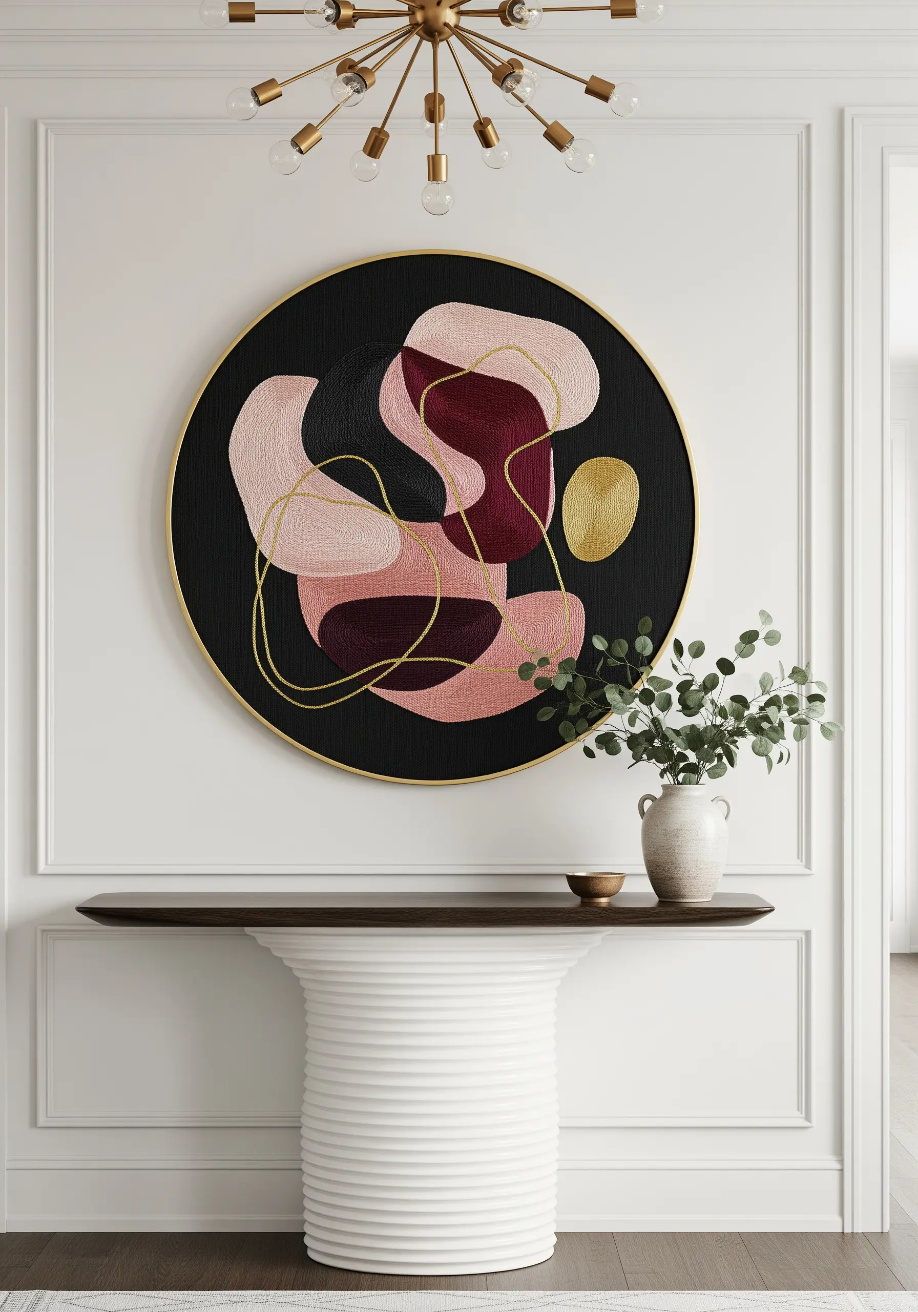 A large, circular embroidery with abstract pink and burgundy shapes outlined in gold.