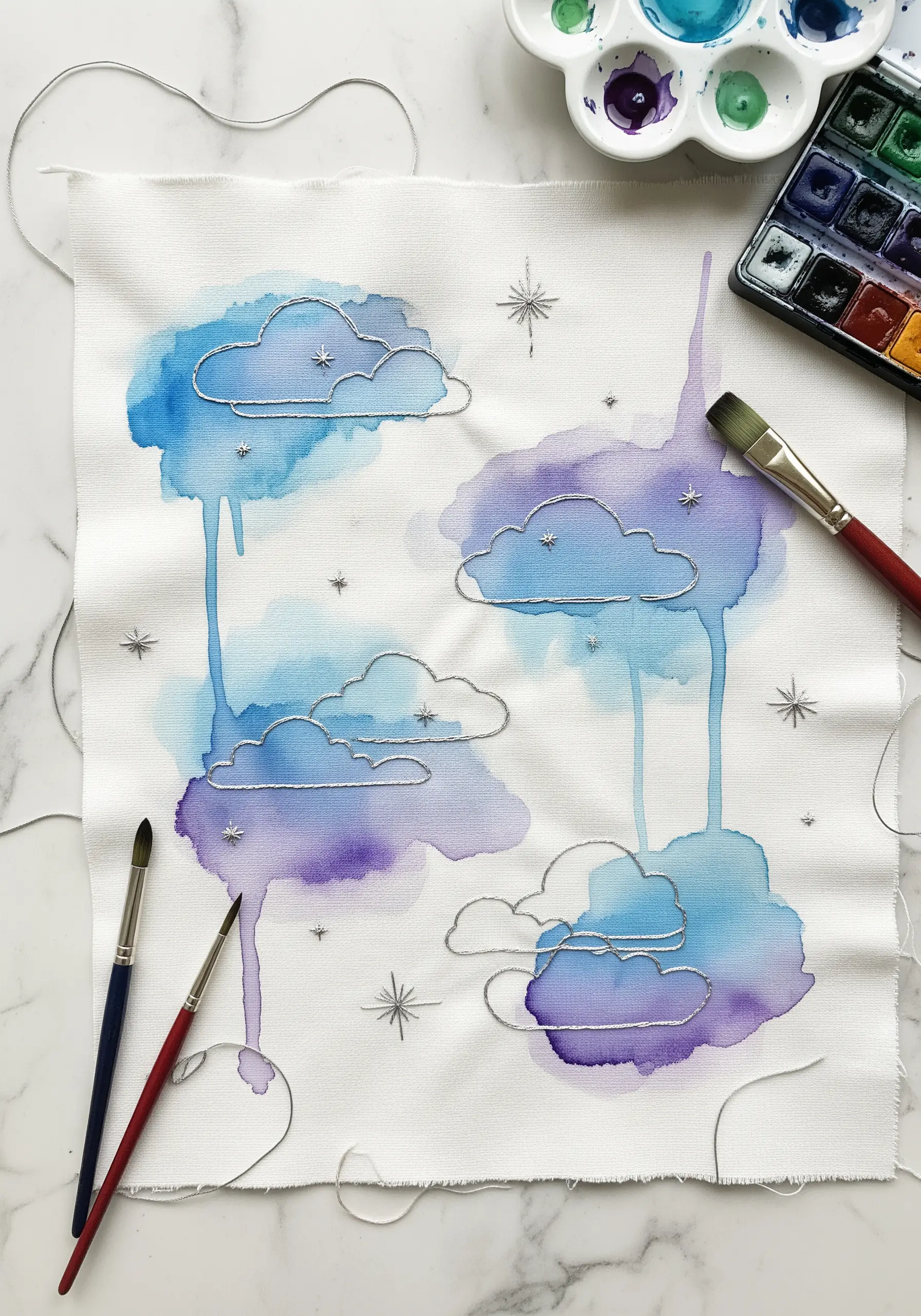 Blue and purple watercolor clouds on white fabric, outlined with silver embroidery thread.