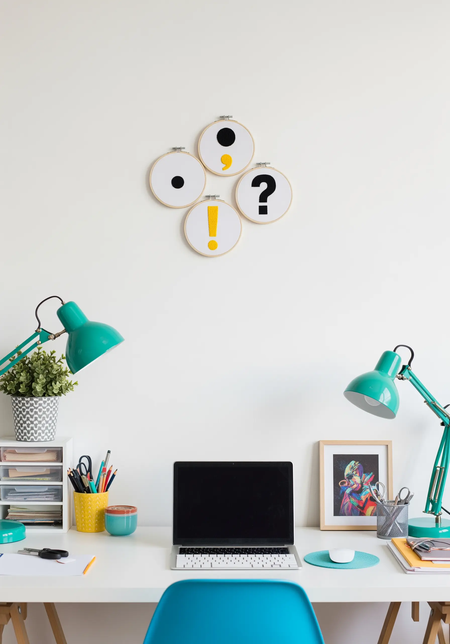 Four small embroidery hoops, each with a different punctuation mark.