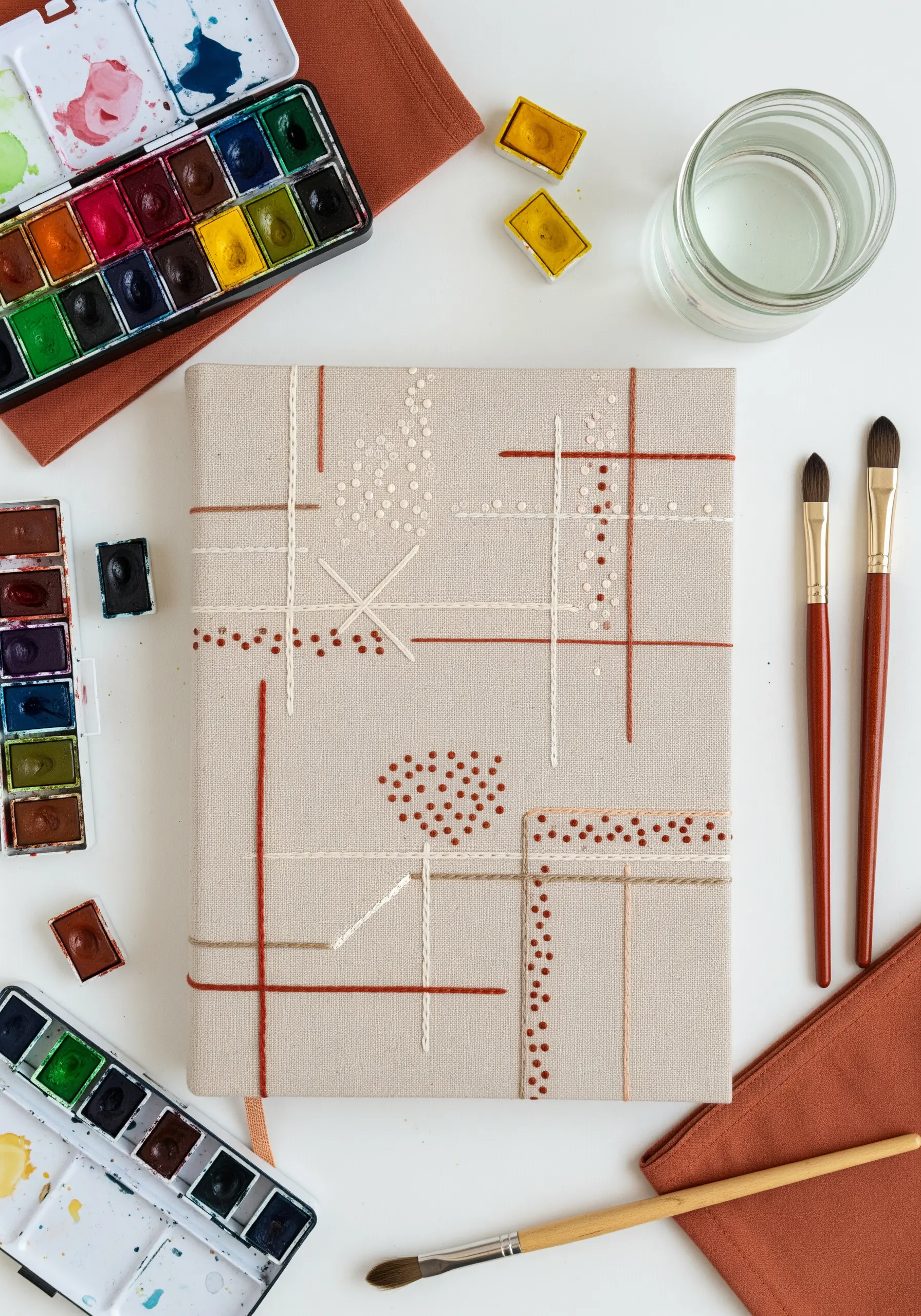 Abstract grid design with French knot accents on a canvas journal cover