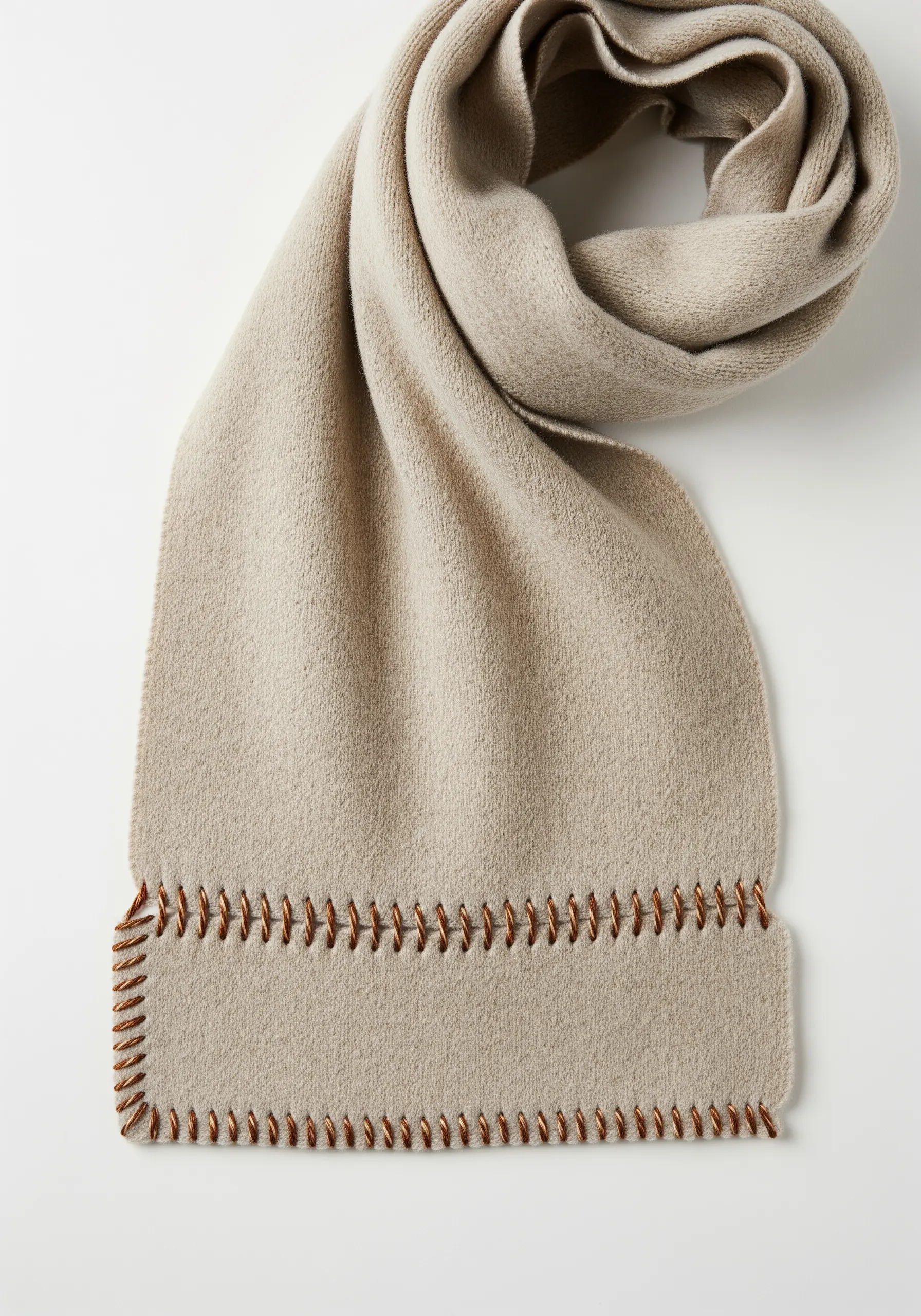 A decorative blanket stitch in contrasting brown thread along the hem of a beige scarf.