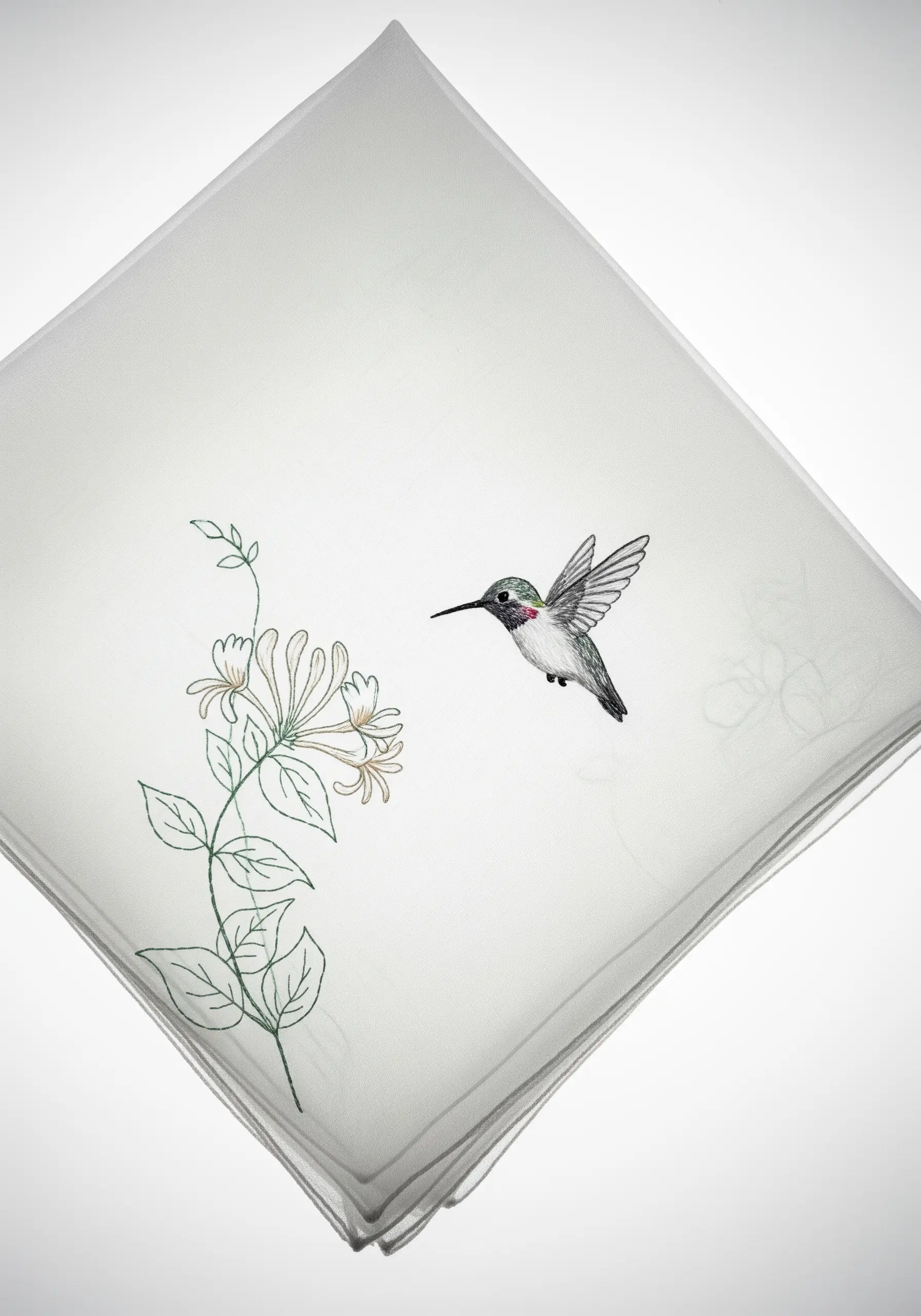 Tiny thread-painted hummingbird flying toward a delicate honeysuckle line drawing.