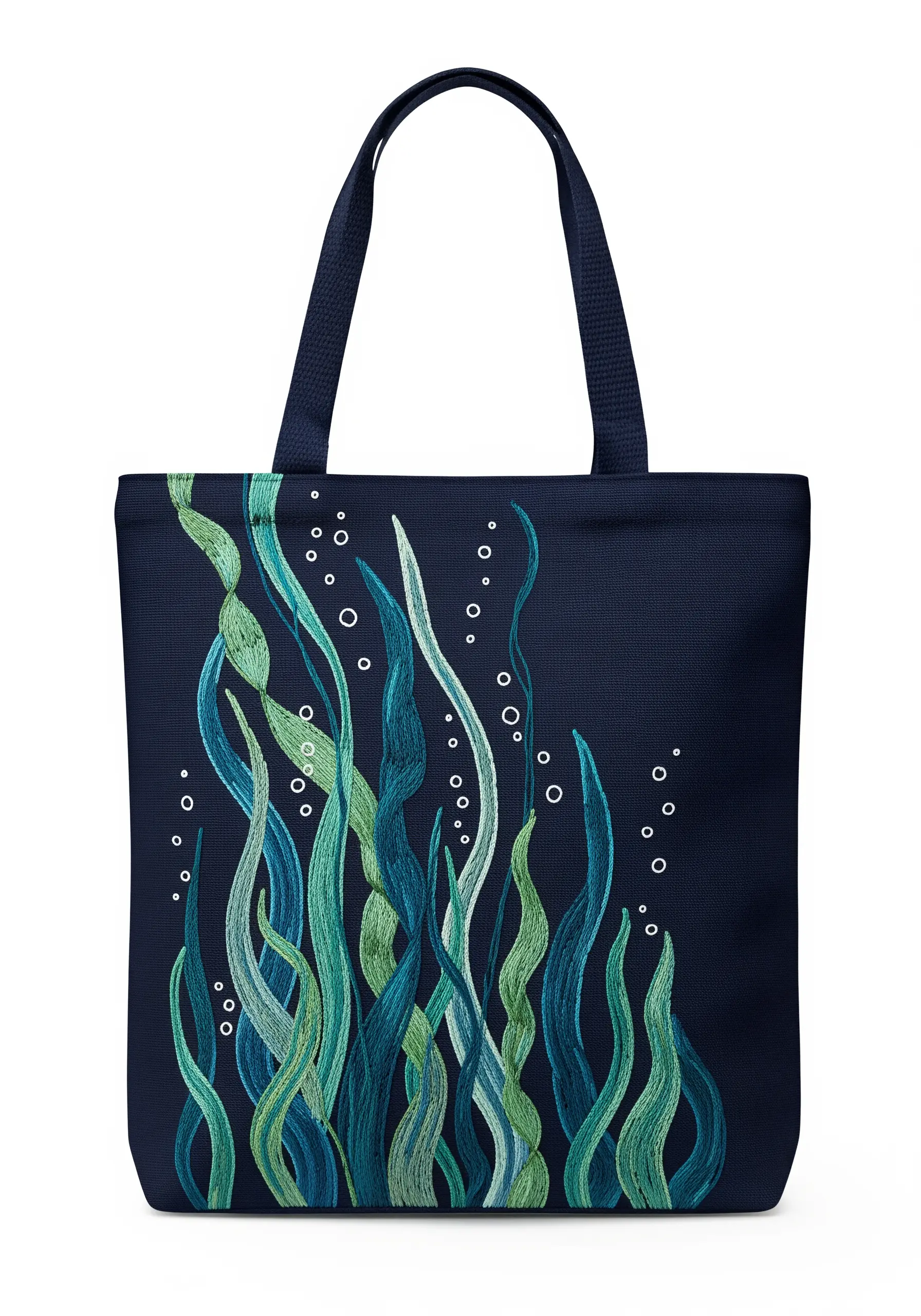 Flowing seaweed fronds embroidered in shades of blue and green on a navy tote bag