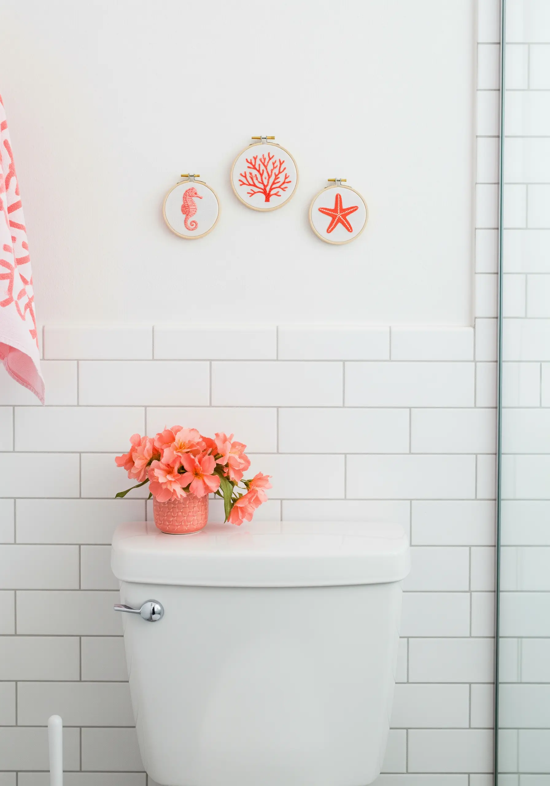 Trio of mini embroidery hoops with a seahorse, coral, and starfish in red.