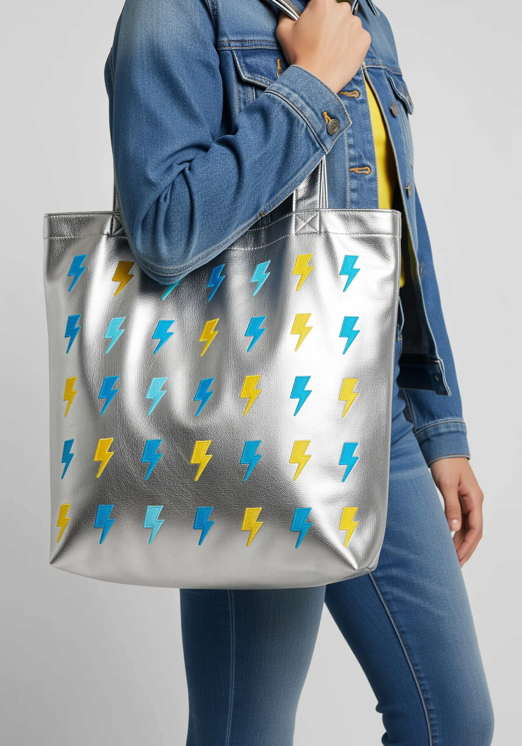 A repeating pattern of blue and yellow lightning bolts on a metallic silver tote.