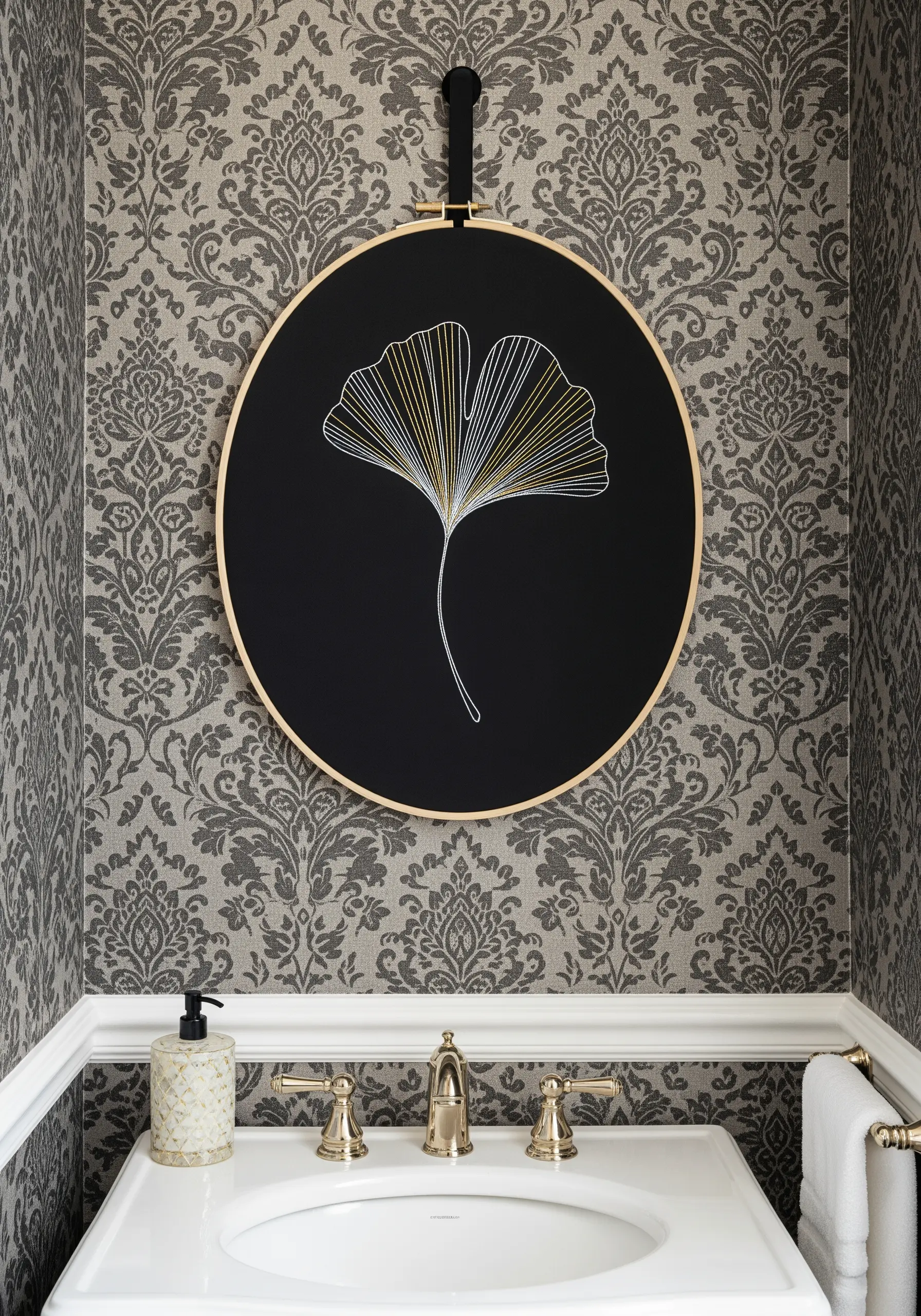 A ginkgo leaf embroidered on black fabric, with threads blending from white to gold.