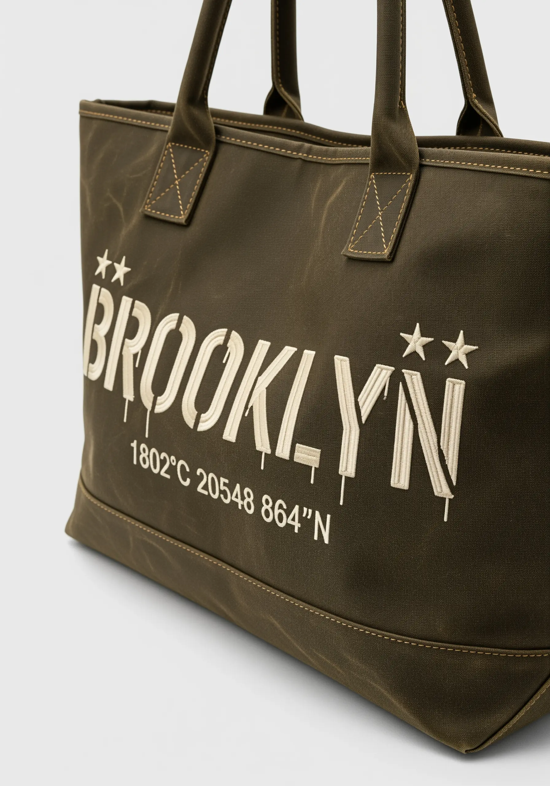 Embroidered 'Brooklyn' text with a drip effect on an olive green tote bag.