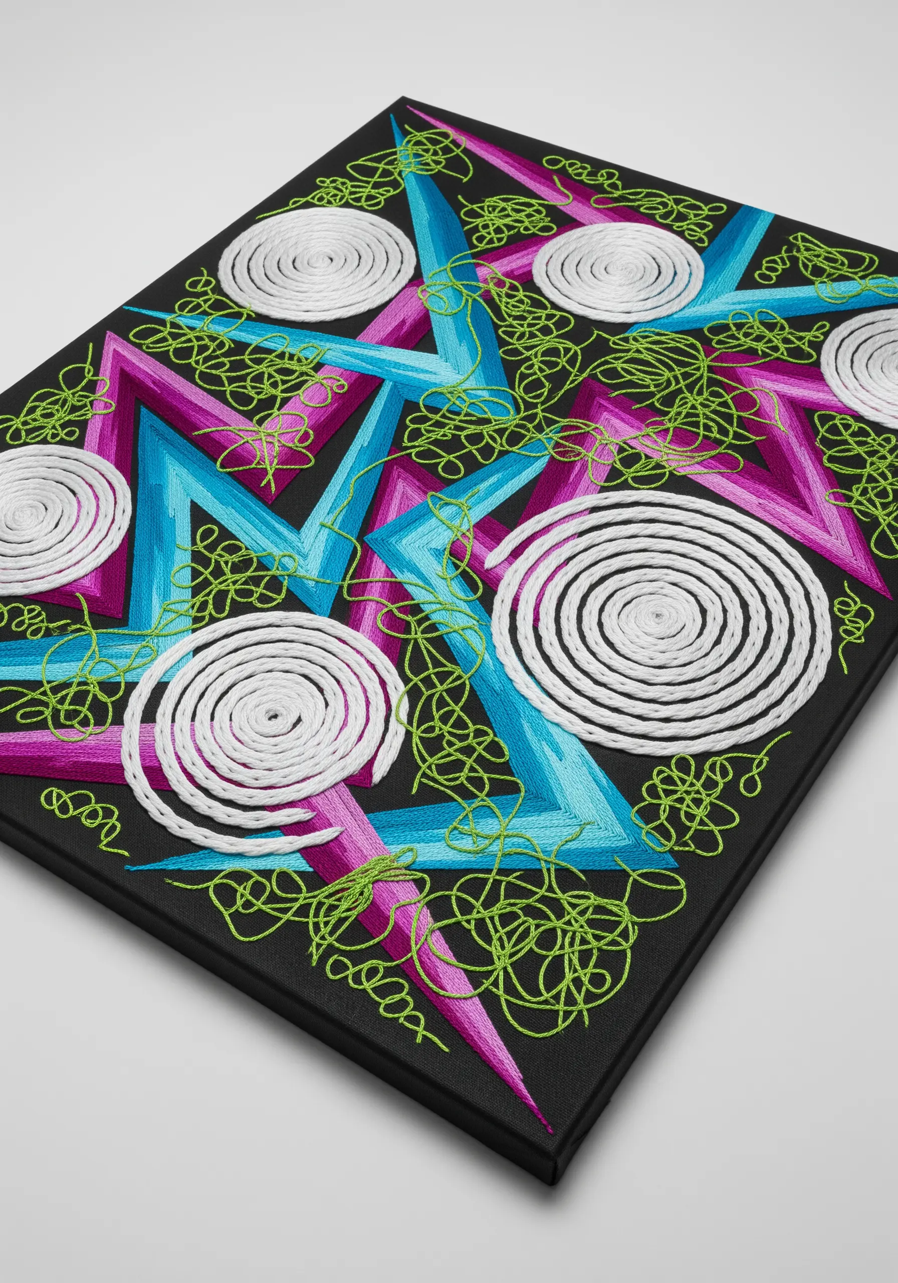 Abstract embroidery with neon green scribbles over magenta and blue zigzags and white spirals.