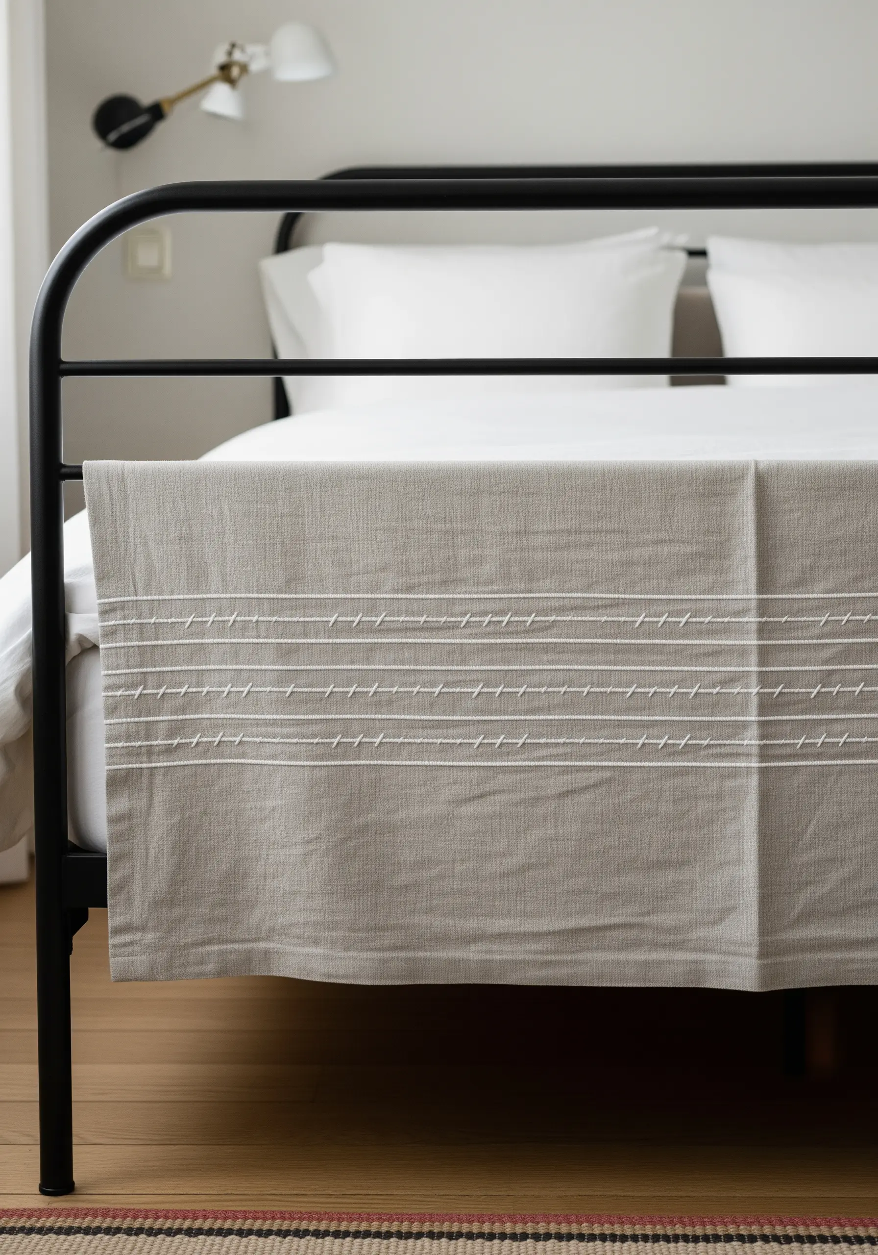 A neutral-colored linen throw with horizontal bands of white, slanted running stitches.