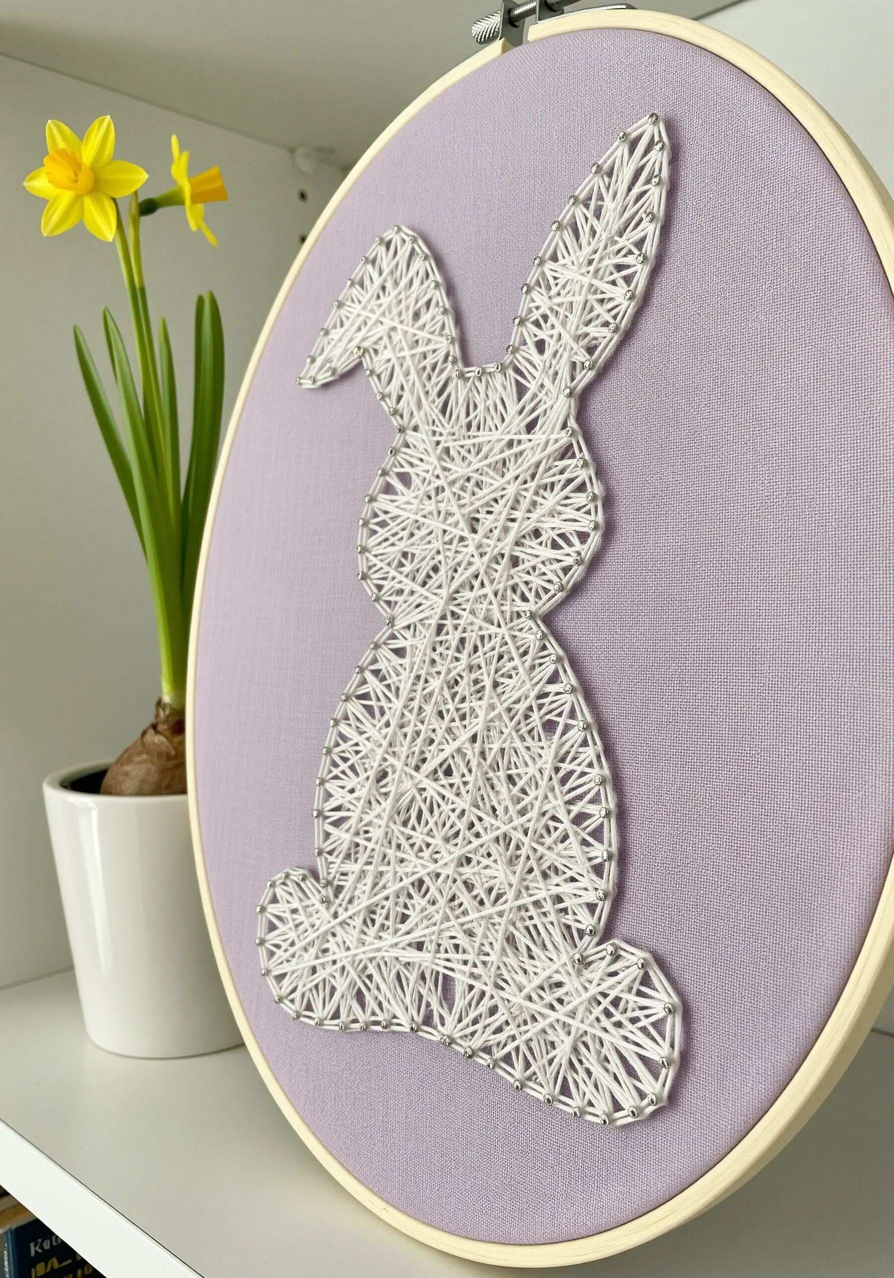 White string art bunny silhouette with a random fill on lavender fabric.