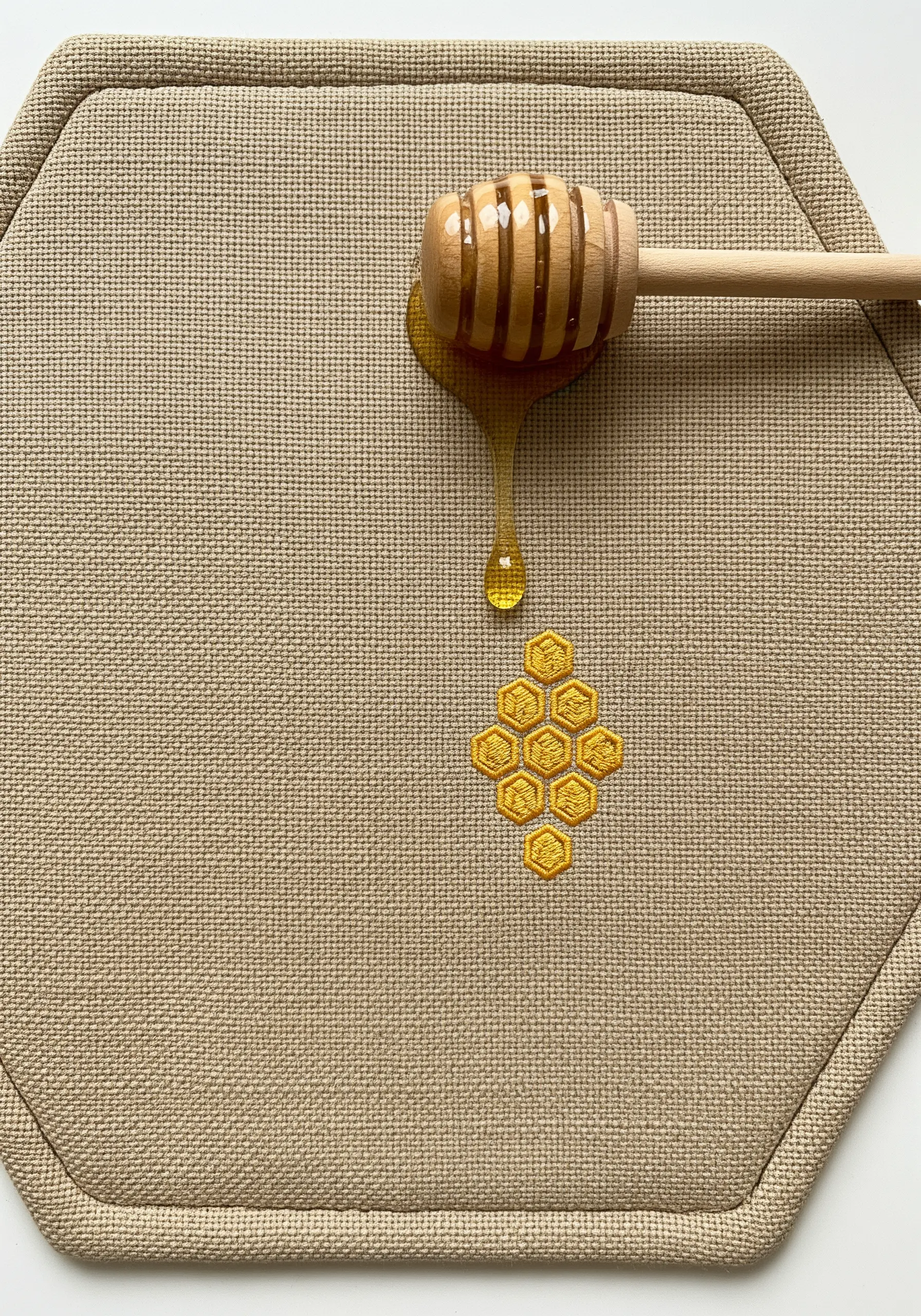 A small embroidered honeycomb motif with satin stitches angled for a 3D effect.