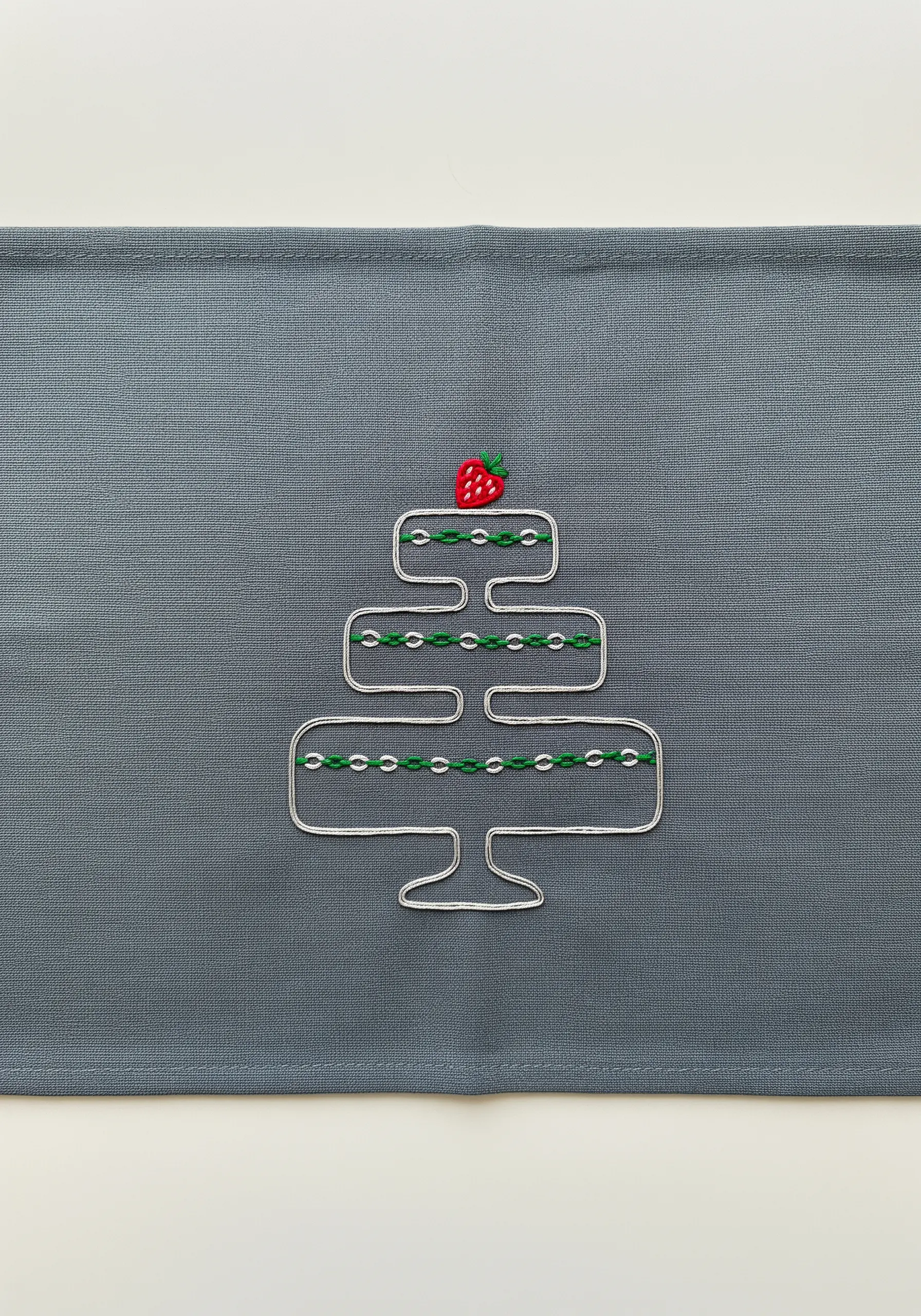 Minimalist line art embroidery of a tiered cake stand with green accents.