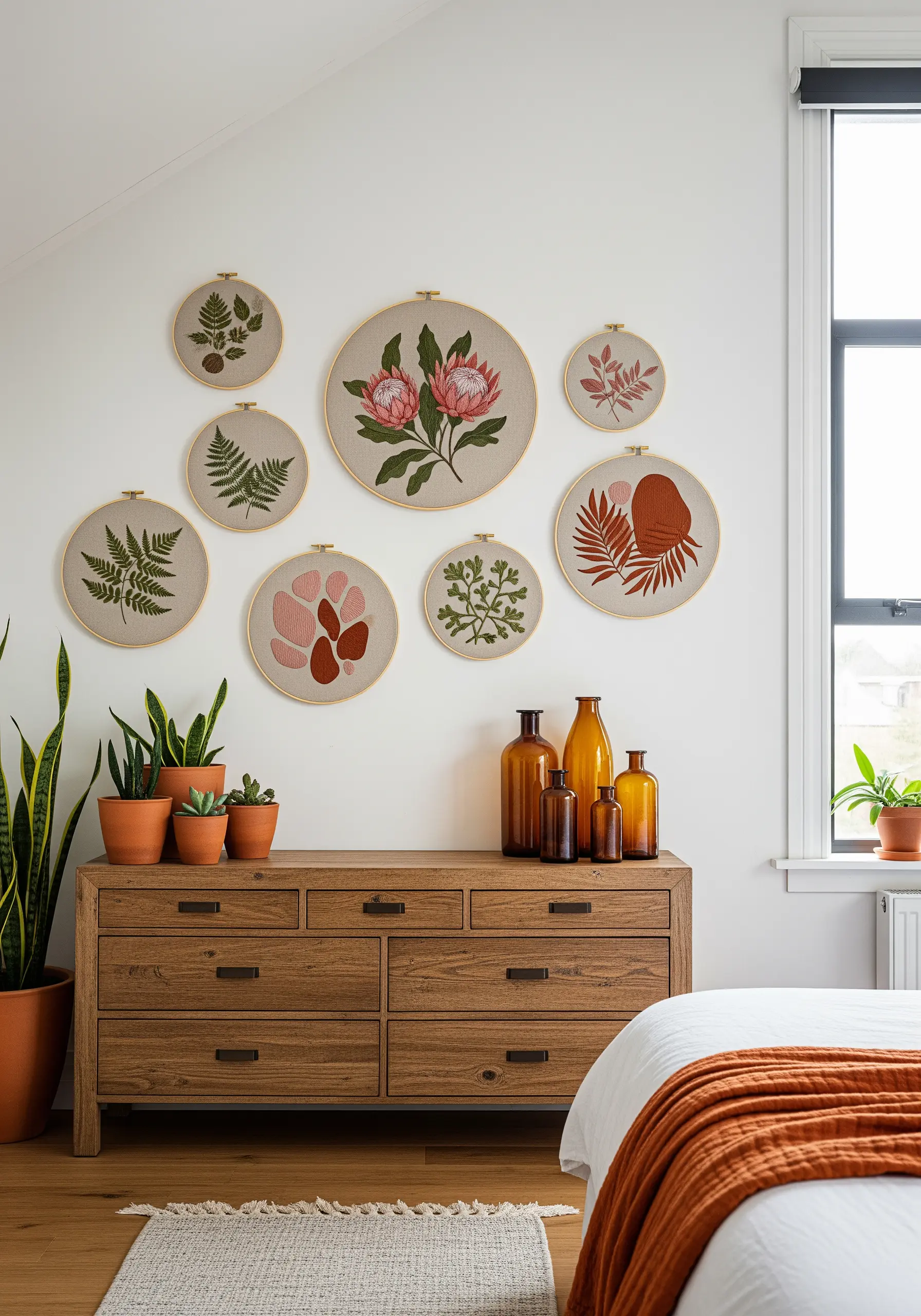 A gallery wall of seven embroidery hoops with various botanical and leaf patterns.