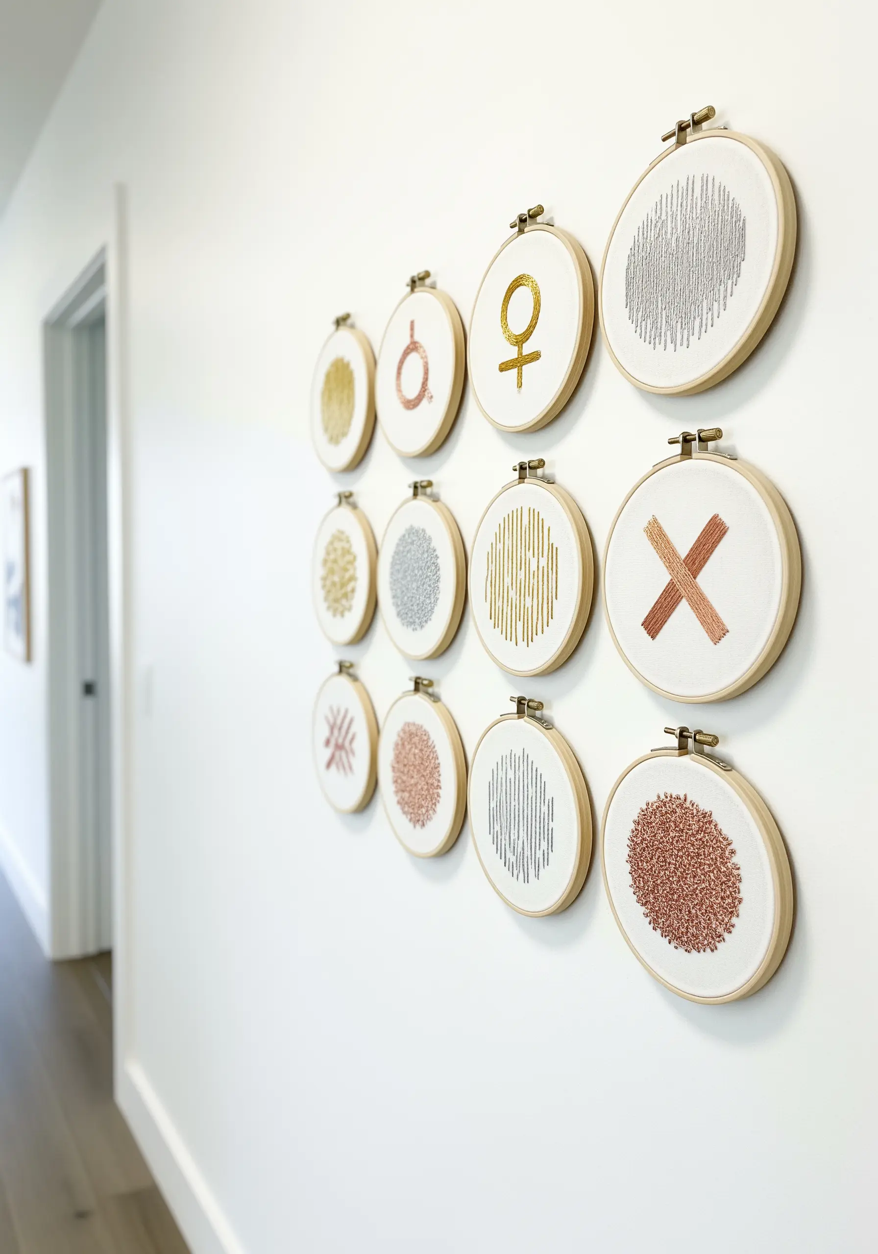 A gallery wall of small embroidery hoops filled with different metallic thread textures and symbols.