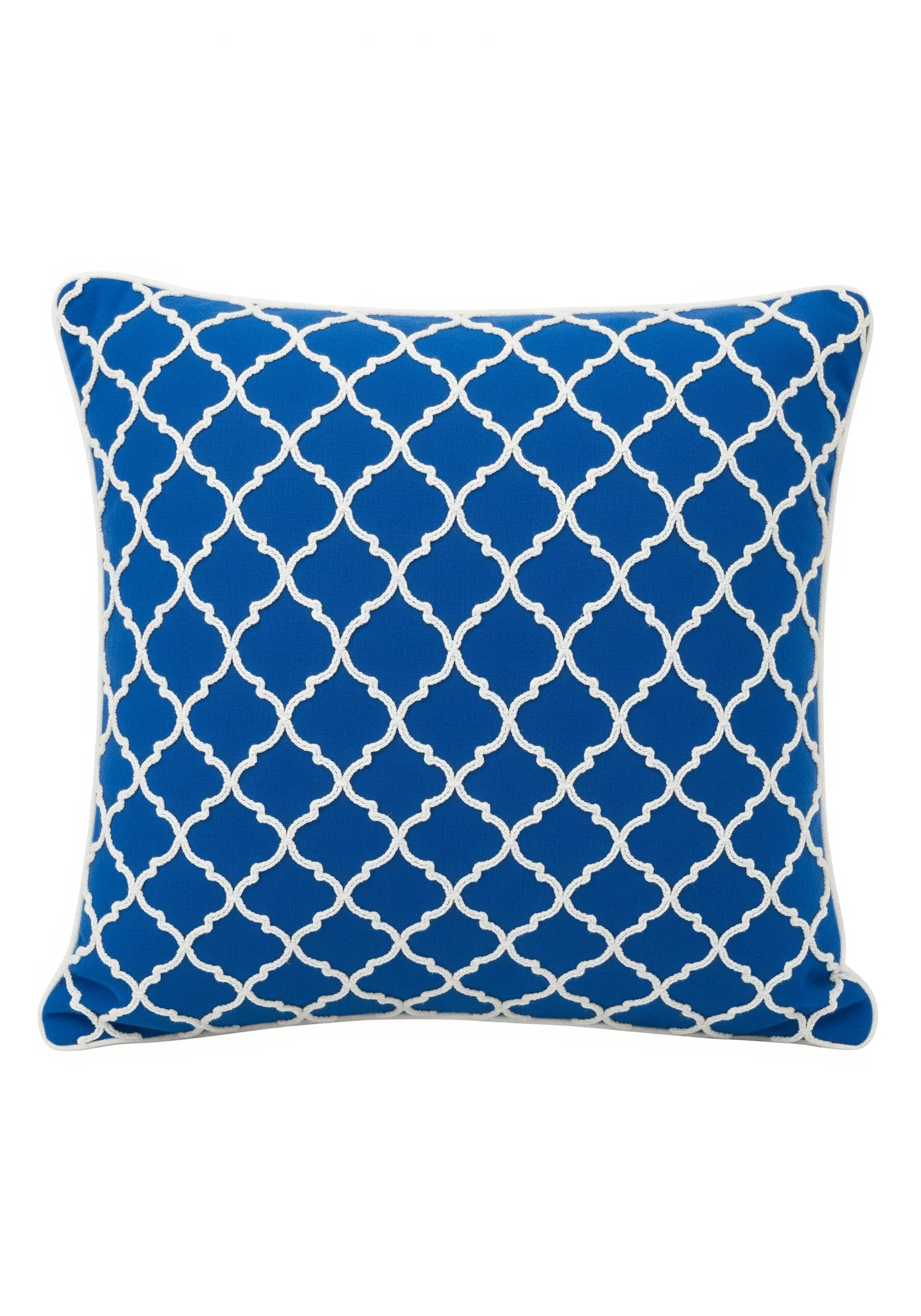 A white Moroccan quatrefoil trellis pattern embroidered on a bright blue cushion