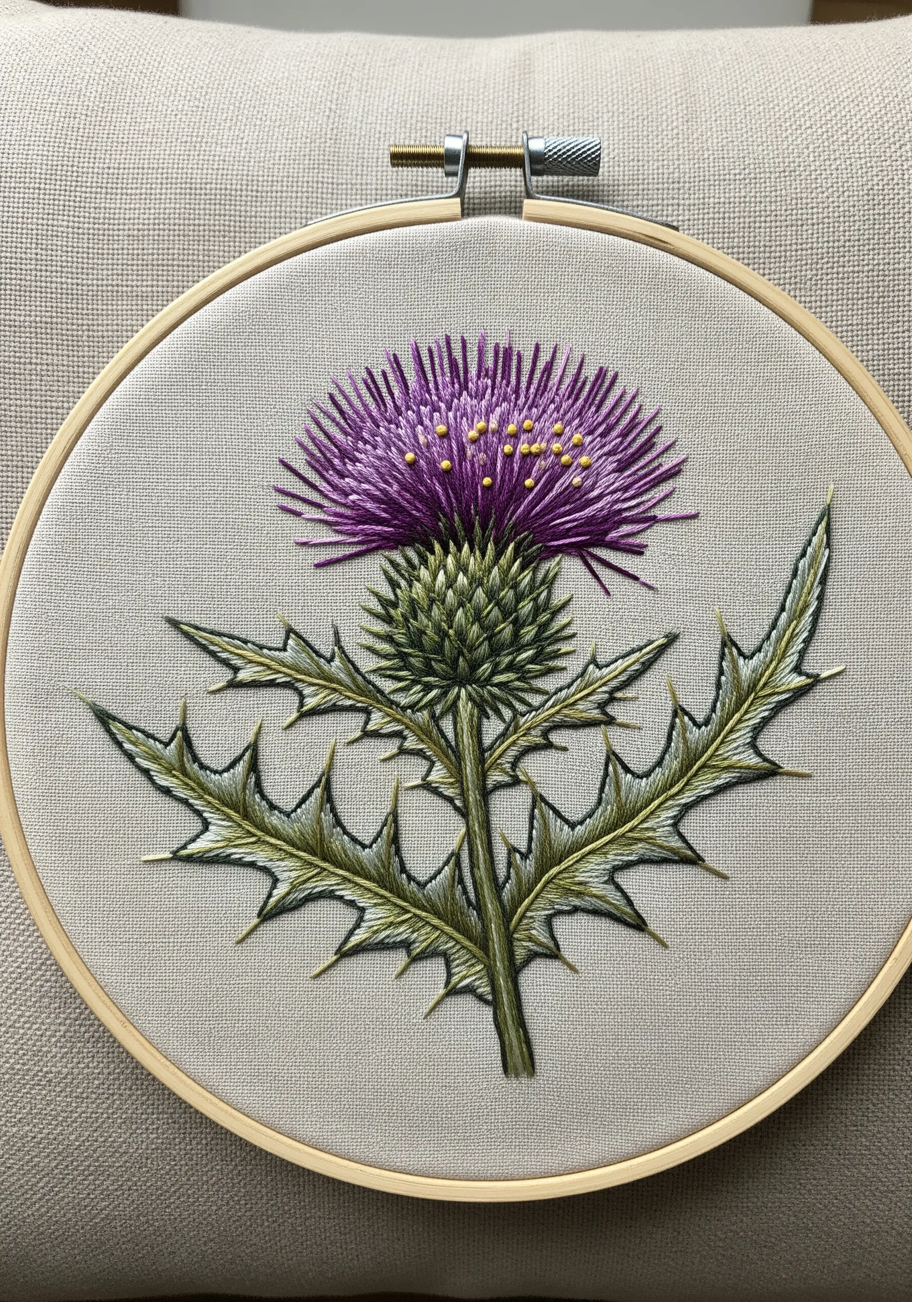 A realistic Scottish thistle embroidered with sharp leaves and a textured purple top.