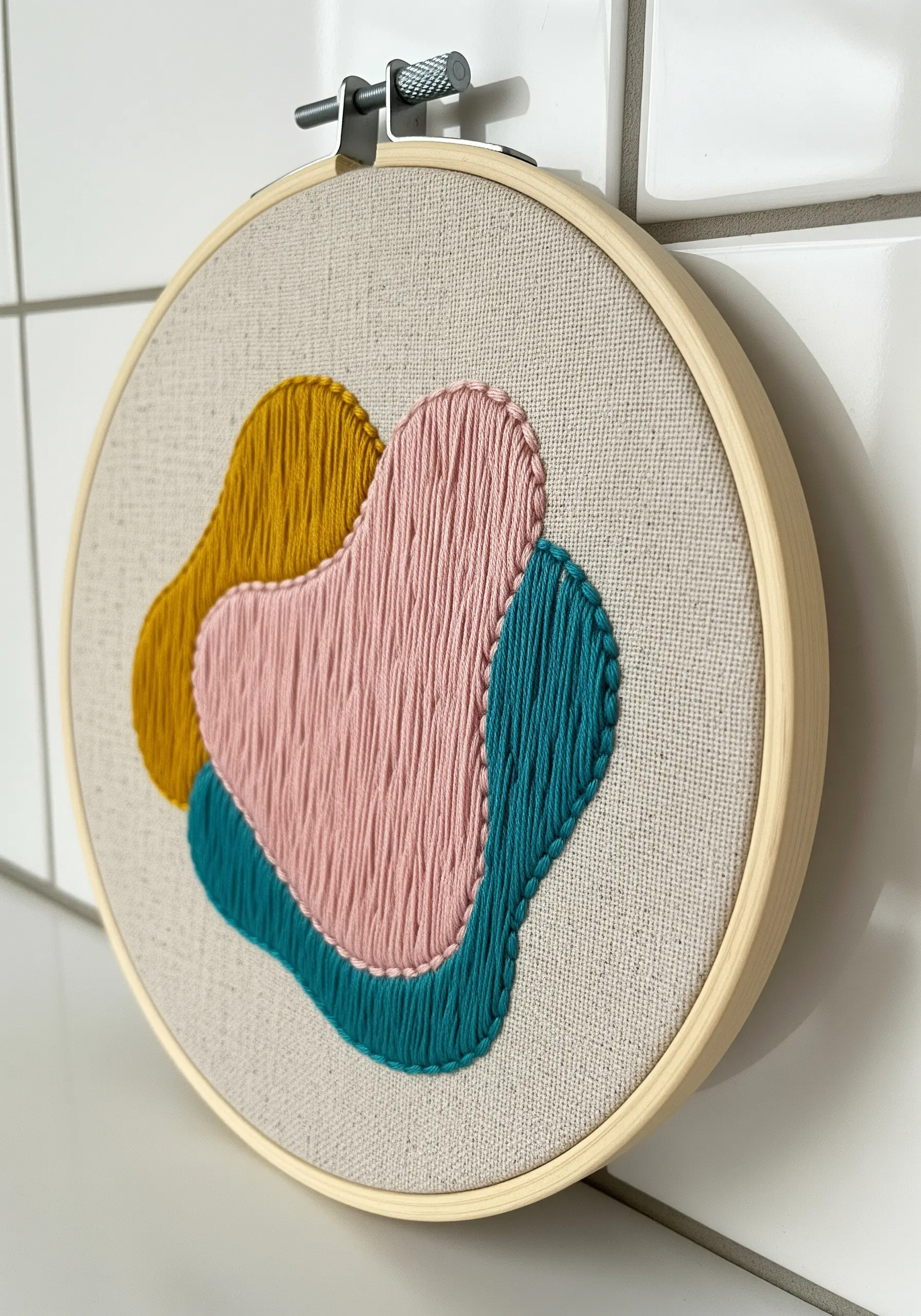 Three overlapping abstract shapes in yellow, pink, and teal with defined outlines.