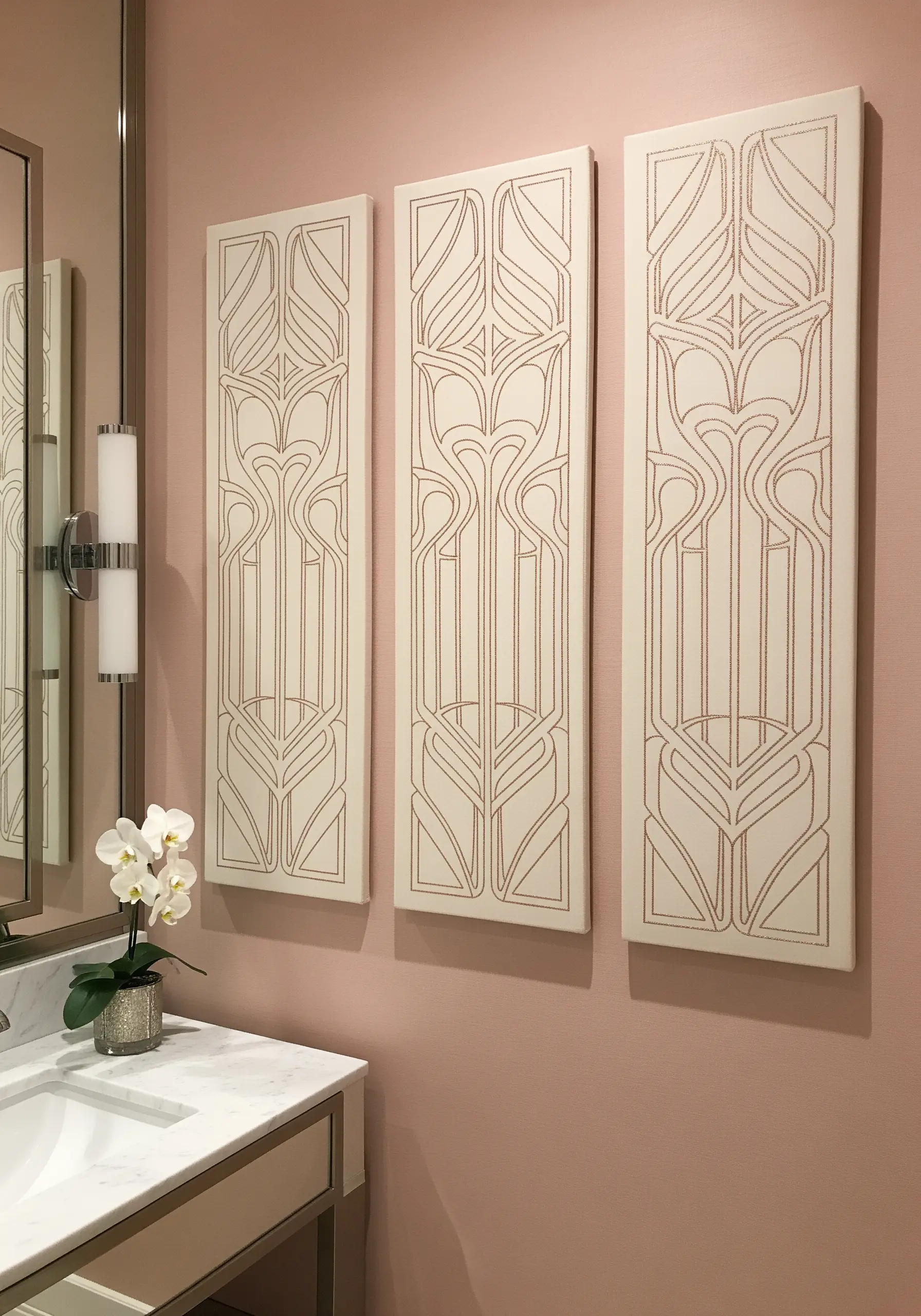 Three vertical panels with Art Nouveau patterns stitched in rose gold thread on cream canvas.